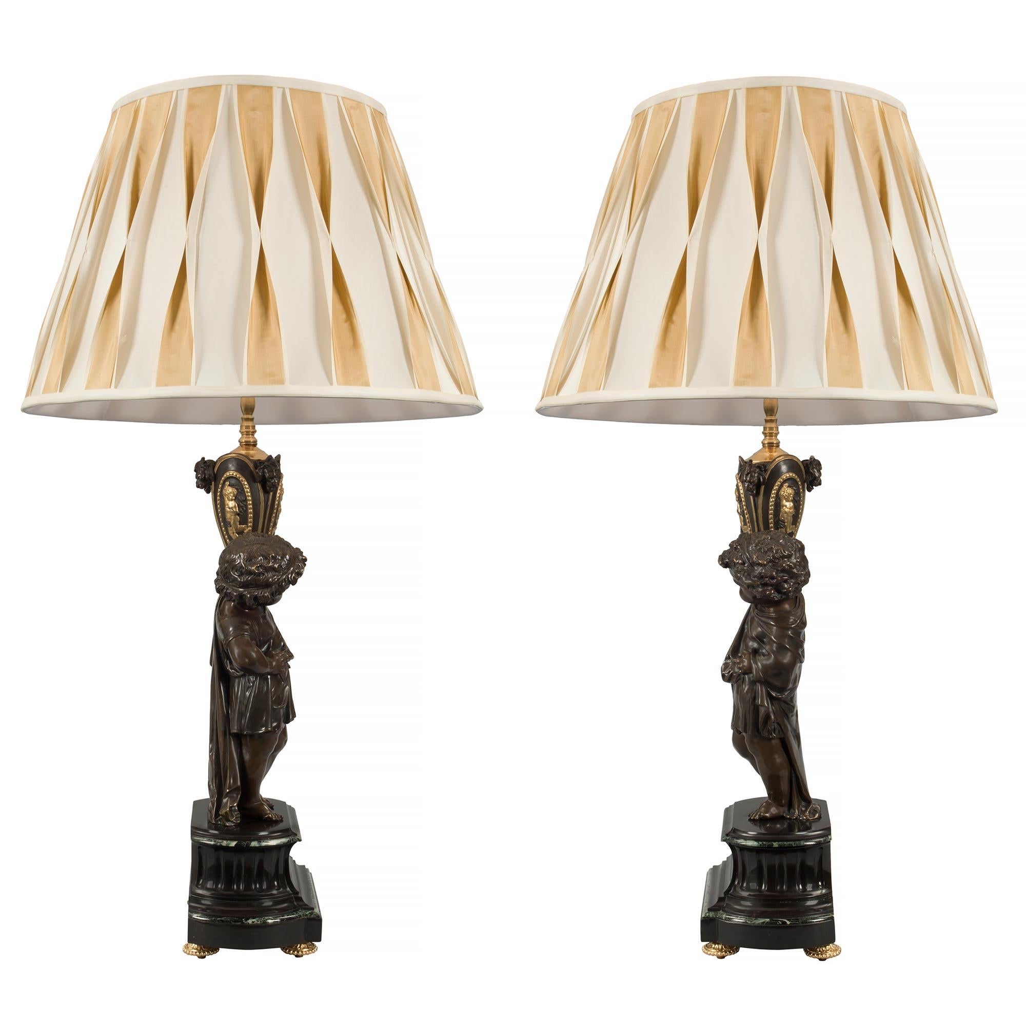 A beautiful and high quality true pair of French 19th century Louis XVI st. Belle Époque period patinated bronze and marble lamps. Each lamp is raised by a striking black Belgian and Vert de Patricia marble base with ormolu topie shaped feet and and