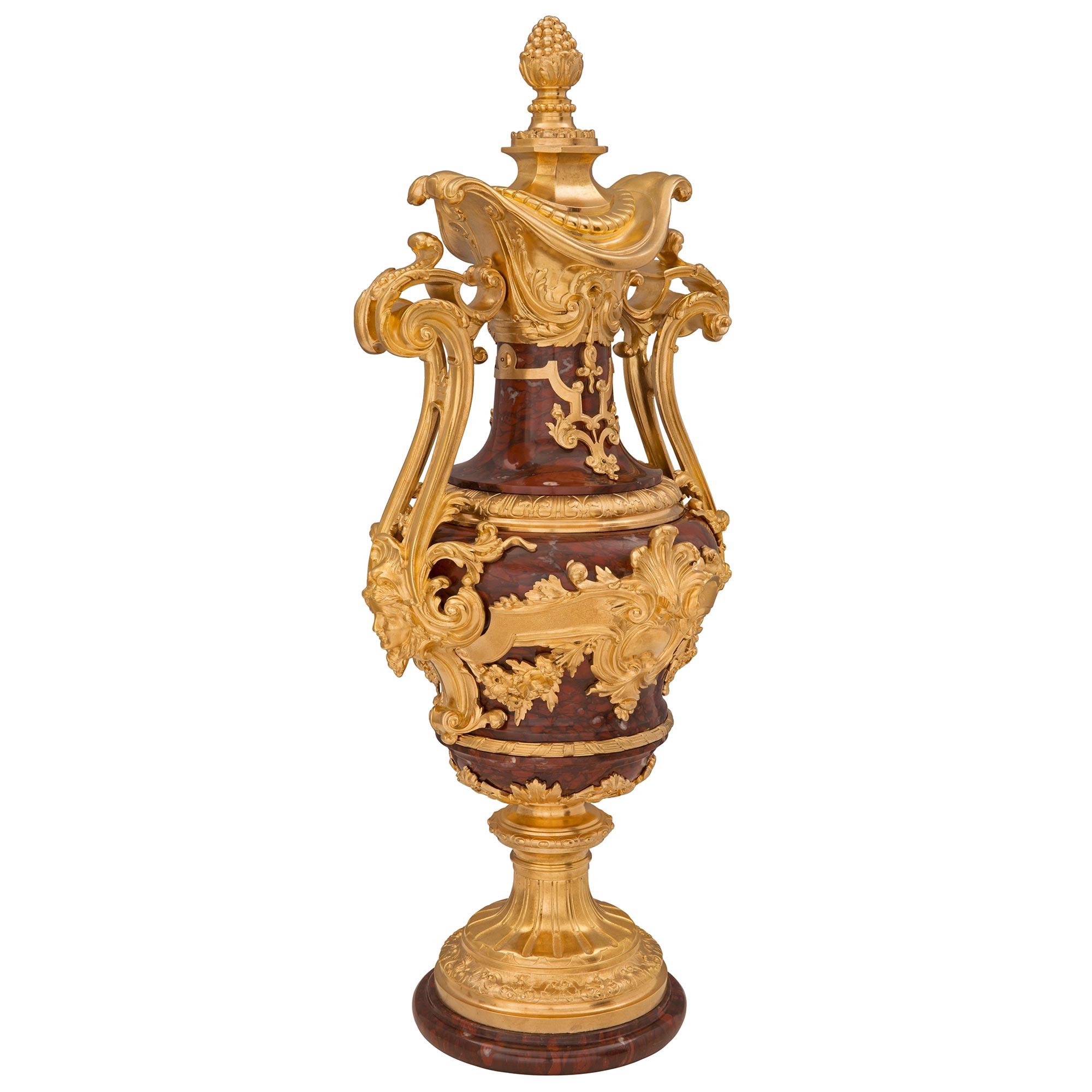 A stunning and extremely high quality pair of French 19th century Louis XVI st. Belle Époque period Rouge Griotte marble and ormolu urns, signed Ferdinand Barbedienne. Each most impressive urn is raised by a circular Rouge Griotte marble base with a
