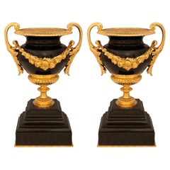 Paire d'urnes en marbre noir de Belgique et bronze doré de style Louis XVI du XIXe siècle