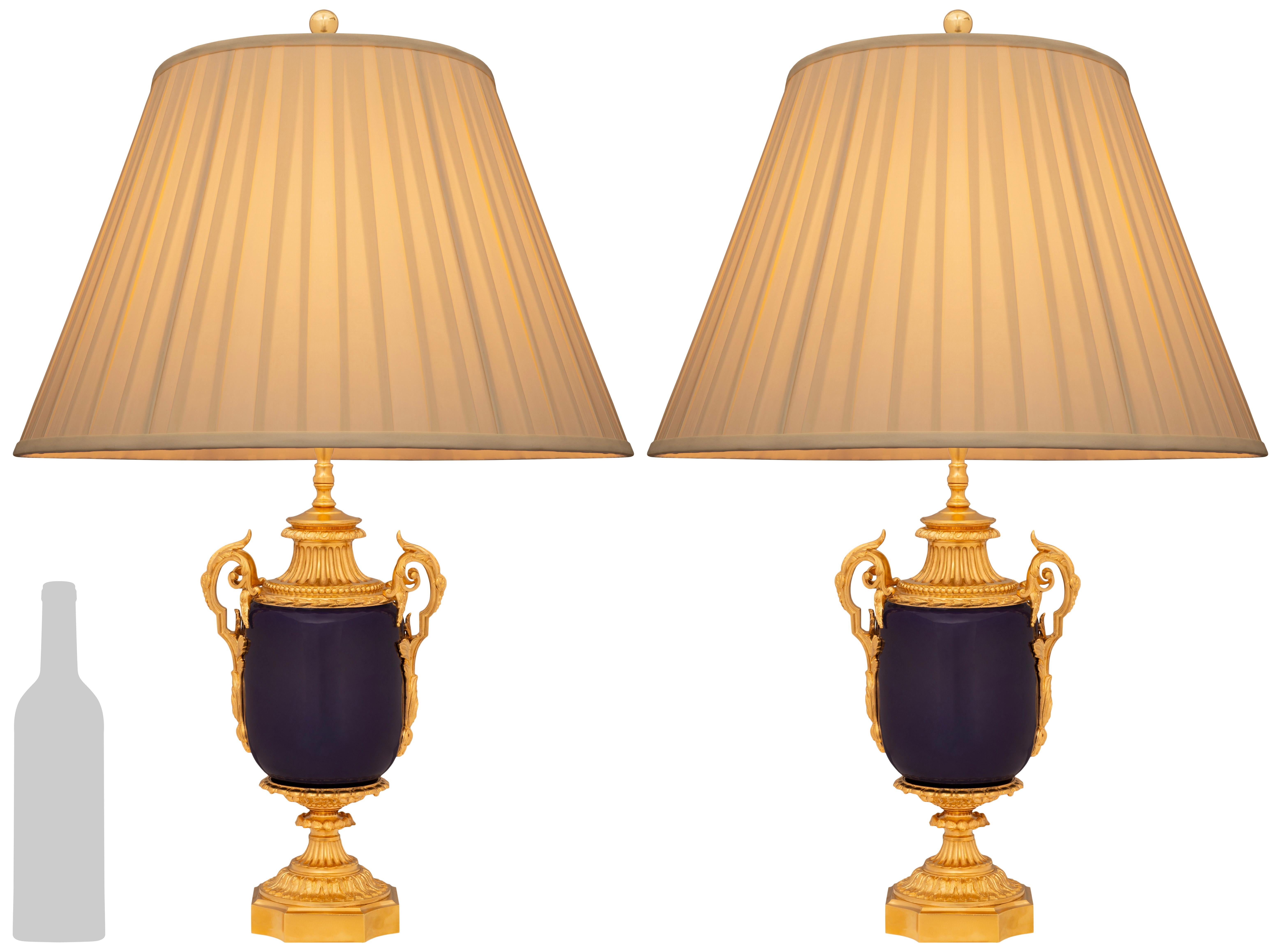 A stunning and high quality pair of French 19th century Louis XVI st. cobalt blue Sévres Porcelain and Ormolu lamps. Each beautiful lamp is raised on a fine square Ormolu base with concave corners and a socle pedestal above which displays draping