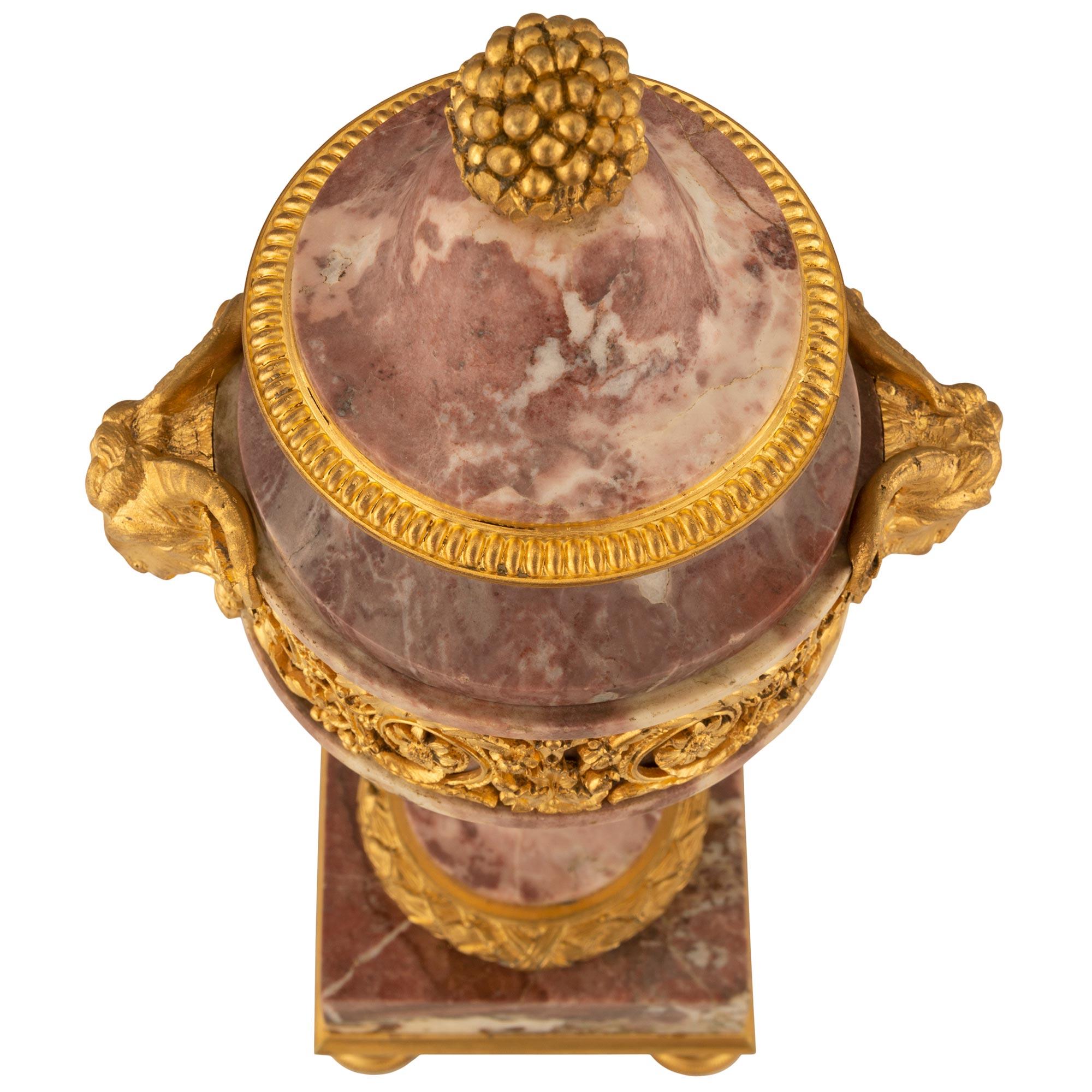 Bellissima coppia di urne in marmo e ormeggio Brèche Violette francesi del XIX secolo. Ciascuna urna è sollevata da raffinati piedi circolari scanalati in ormolu screziato sotto una base rettangolare in marmo Brèche Violette con un'affascinante base