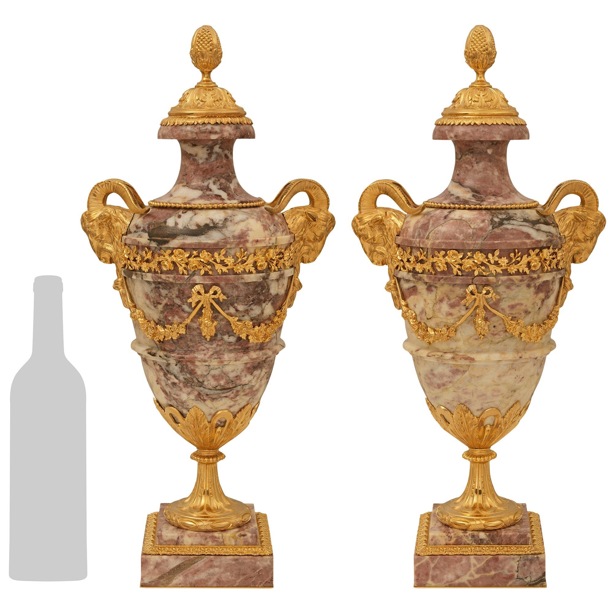 Un'imponente coppia di urne in marmo e ormolu di Violette del XIX secolo, alla maniera di A Link. Ogni splendida urna è sollevata da uno spesso basamento di marmo a gradini decorato da uno squisito bordo di foglie di ghianda in Ormolu. Sopra c'è