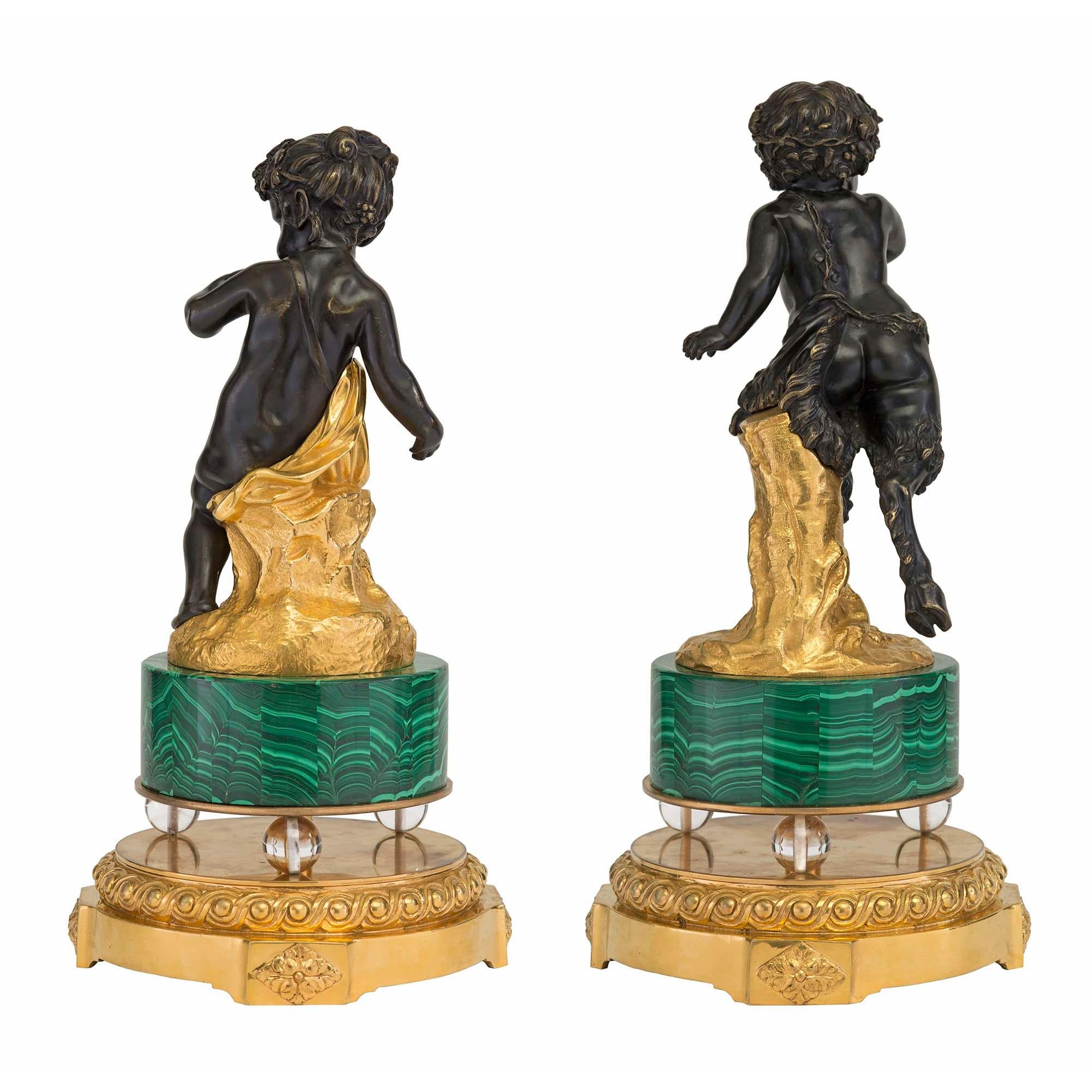 Ein schönes und einzigartiges Paar französischer Statuen aus dem 19. Jahrhundert aus patinierter Bronze, Ormolu, Malachit und Kristall. Jede hochwertige Statue steht auf einem runden Ormolu-Sockel mit Blockrosetten und einem auffälligen