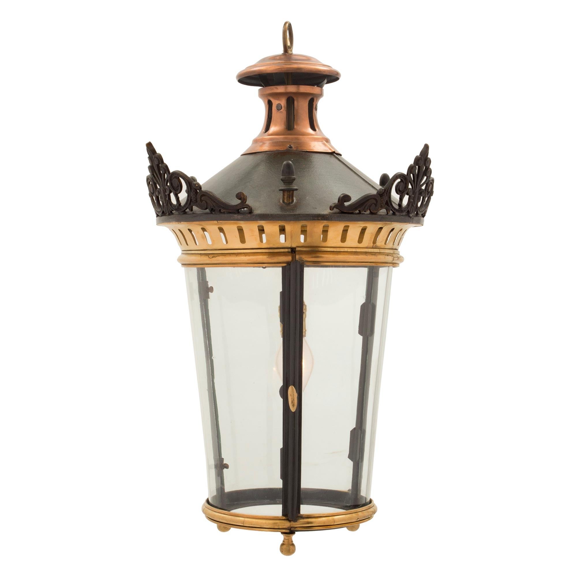 A striking pair of French 19th century Louis XVI st. patinated bronze, ormolu and copper lanterns. Each lantern displays a bottom mottled ormolu band with three most decorative ormolu bands. The curved glass windows are framed within patinated