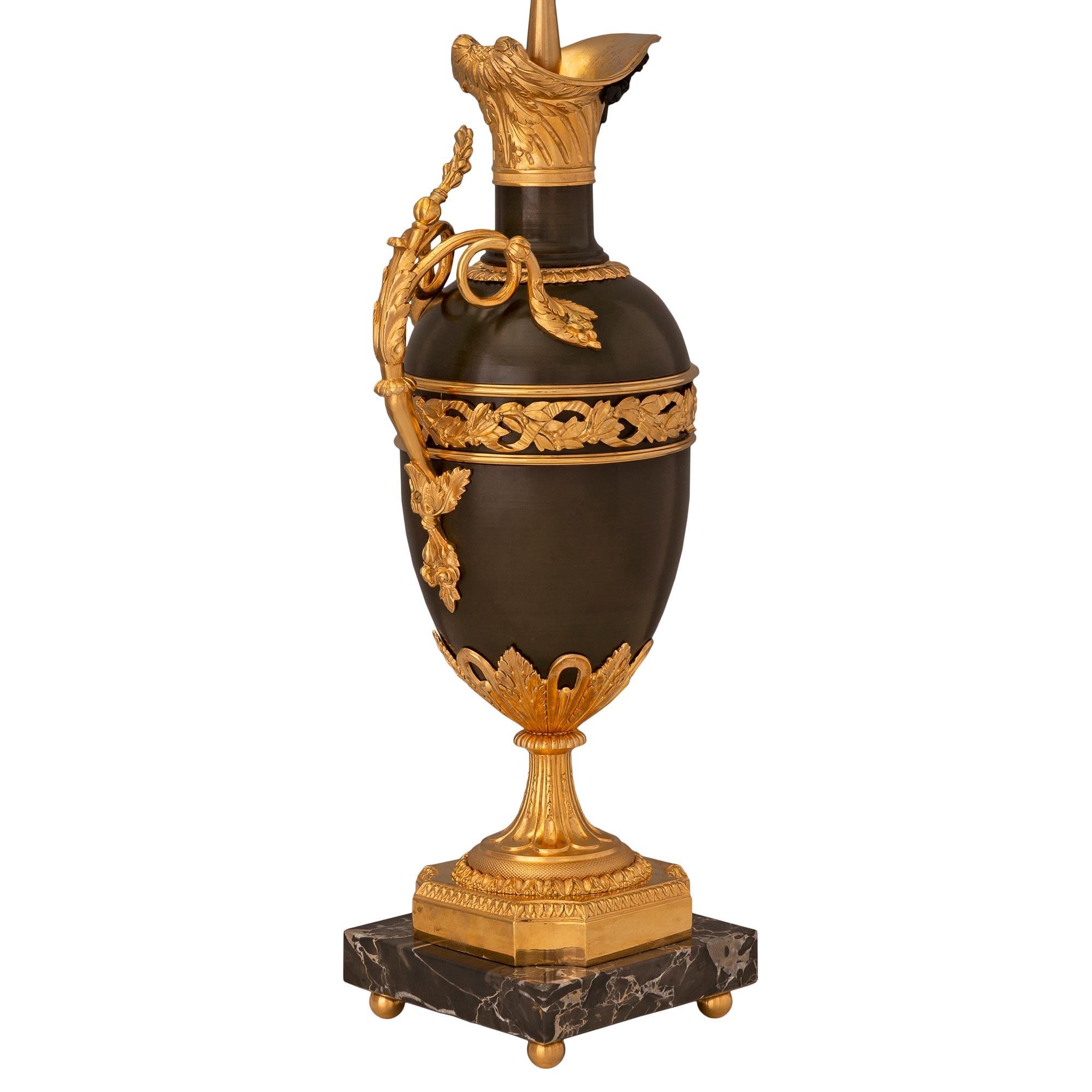 Paire de lampes en bronze patiné, bronze doré et marbre Portoro du XIXe siècle de style Louis XVI, d'une grande élégance et d'une grande qualité. Chaque lampe est surélevée par de fins pieds boules en bronze doré sous les bases carrées en marbre