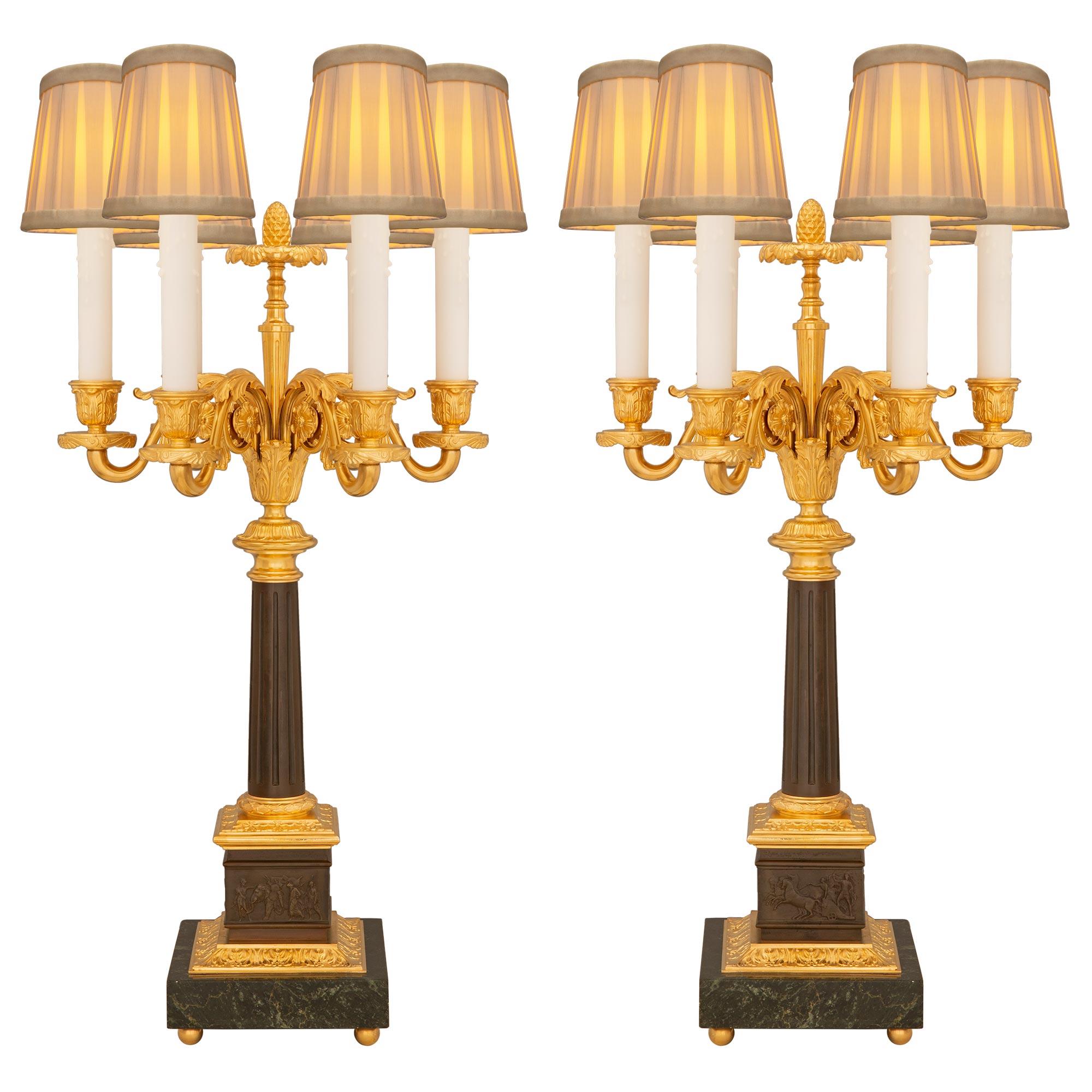 An impressive pair of French 19th century Louis XVI st. patinated bronze, ormolu, and Vert de Patricia marble candelabra lamps. Each six arm lamp is raised by a square Vert de Patricia marble base with fine ormolu ball feet and a richly chased wrap