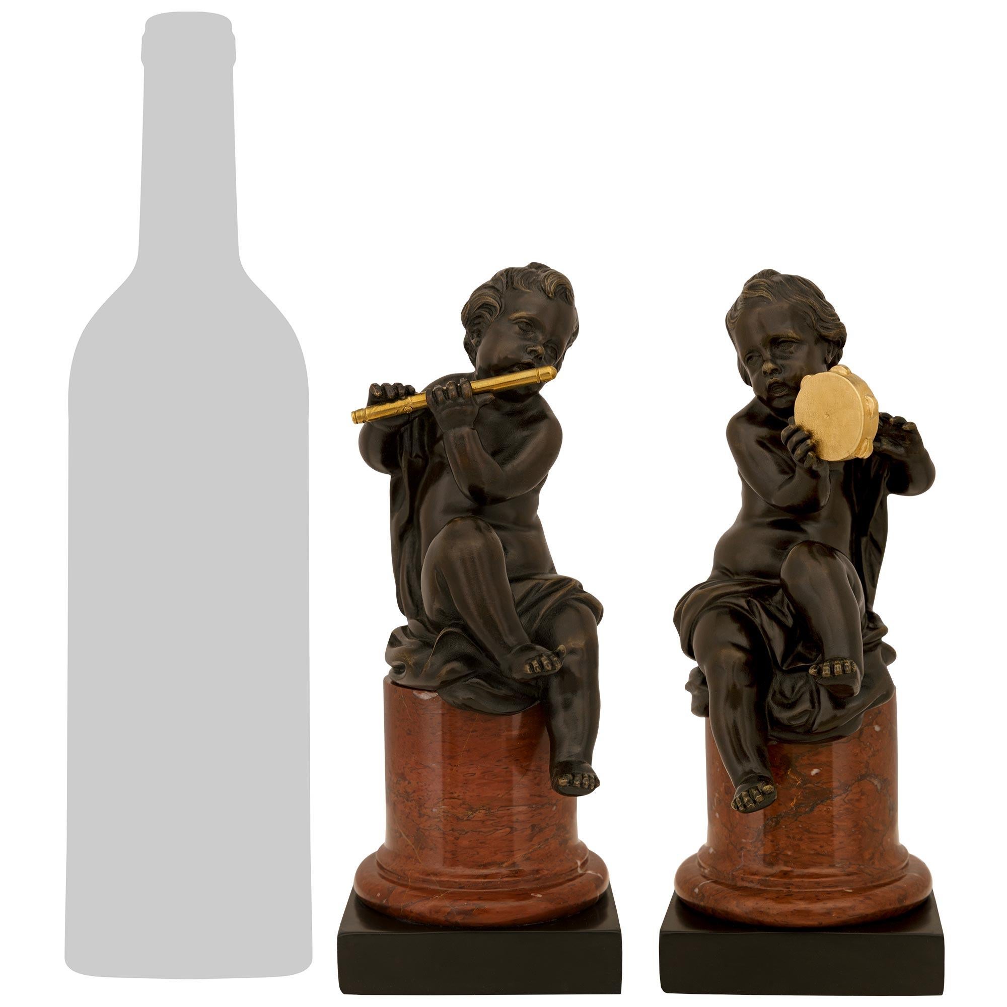 Un'affascinante coppia di statue di charme francesi del XIX secolo in bronzo patinato, Ormolu e marmo. Questa meravigliosa coppia è sollevata da uno zoccolo quadrato in marmo nero belga che sovrasta una colonna circolare screziata in marmo Rouge
