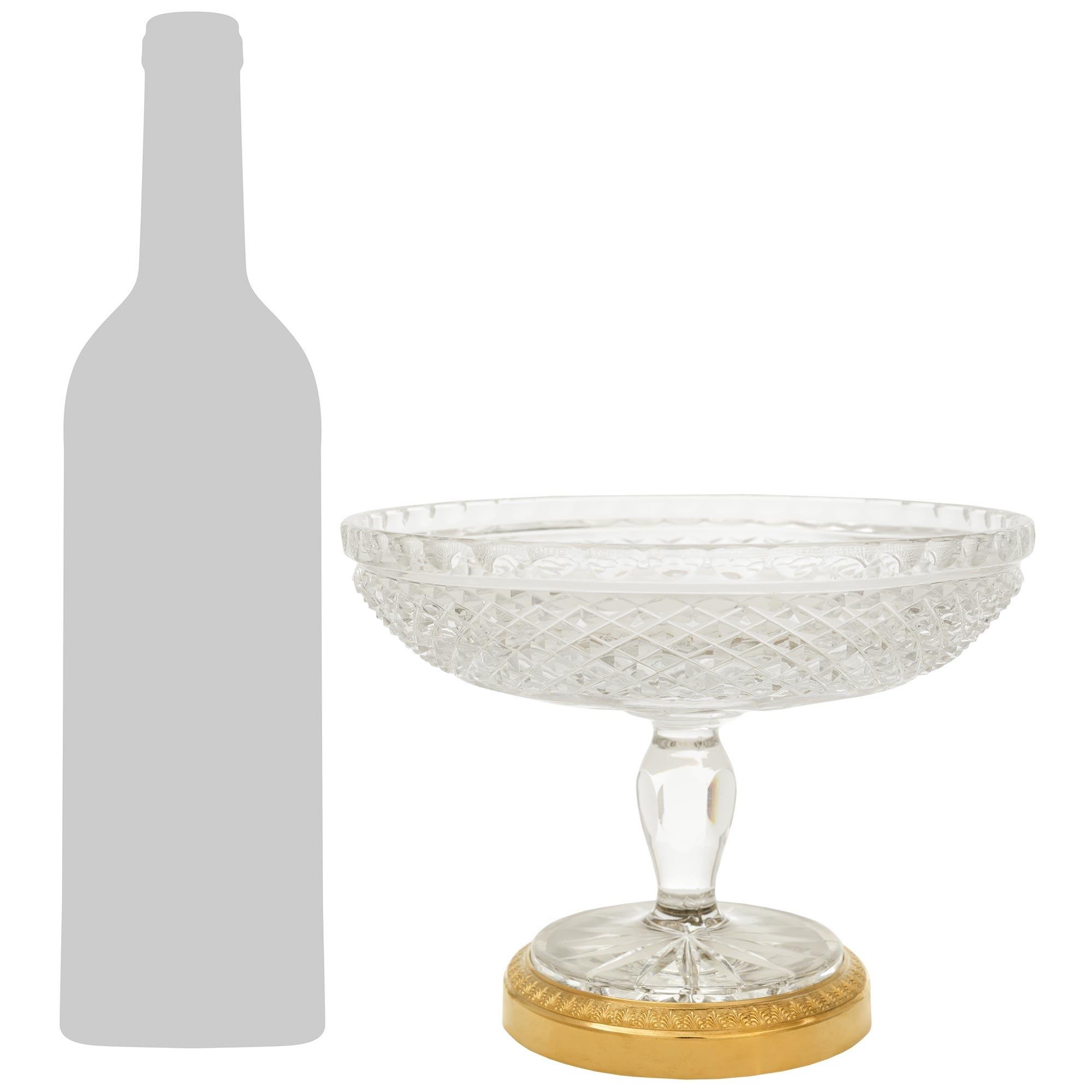 Une élégante paire de tazzas en cristal et bronze doré de style Louis XVI du XIXe siècle, attribuée à Baccarat. Cette charmante paire repose sur des bases circulaires en bronze doré richement ciselé, ornées de bandes cannelées et de palmettes au