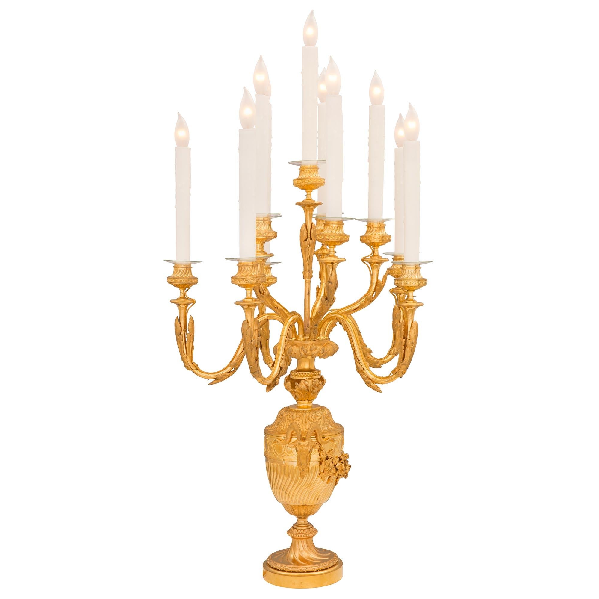 A magnificent pair of French 19th century Louis XVI st. ormolu candelabra lamps. Each eleven arm lamp is raised by an elegant circular base with a beautiful spiral fluted design and richly chased wrap around berried laurel band. The beautifully
