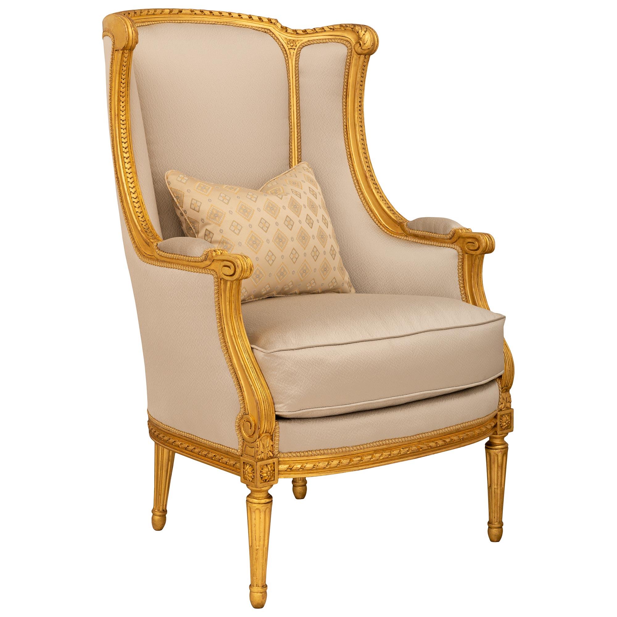 An elegant and high quality pair of French 19th century Louis XVI st. Giltwood Bergère armchairs. Each most elegant chair is raised on four circular fluted tapered legs above oval supports and leading to mottled bands. Above the front legs are