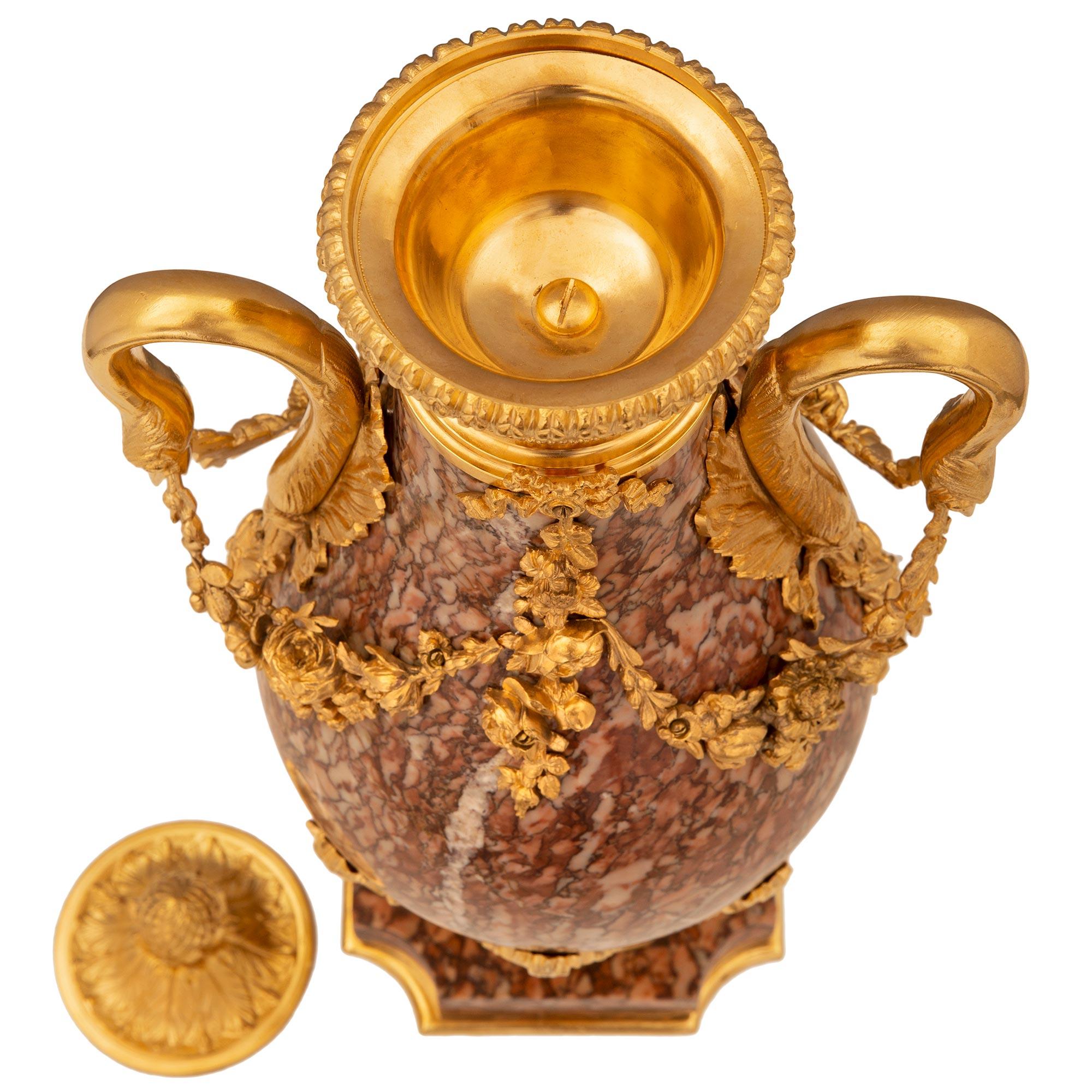 Ein prächtiges Paar französischer Urnen im Stil Louis XVI aus dem 19. Rouge Jaspé de Cazerdane Marmor und Ormolu Deckel Urnen. Jede Urne steht auf einem eleganten quadratischen Sockel mit konkaven Ecken und einer feinen Ormolu-Füllung am Boden. Der