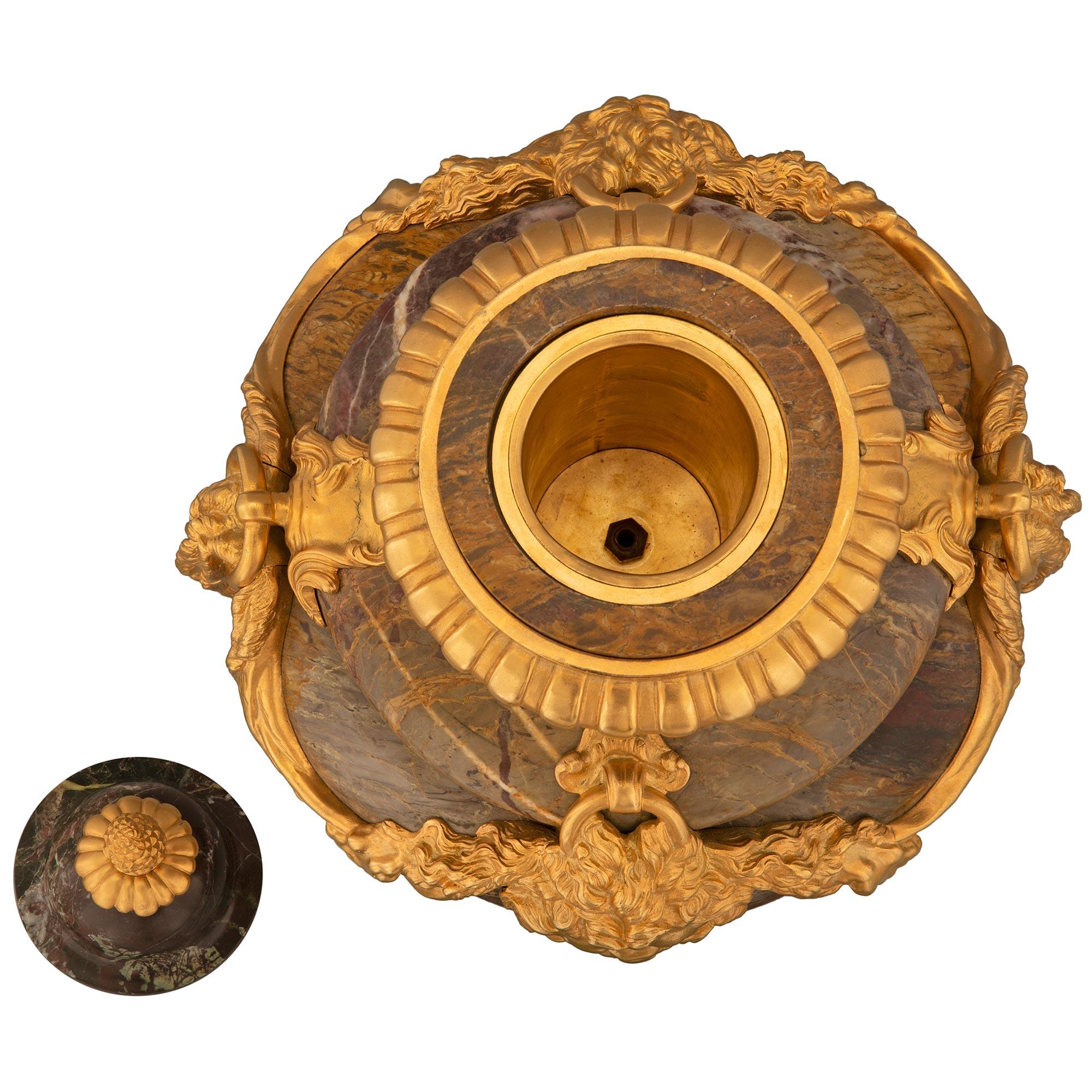 Magnifique et impressionnante paire d'urnes à couvercle en marbre de Sarrancolin et bronze doré, de style Louis XVI, datant du XIXe siècle. Chaque urne de grande taille est surmontée d'une base carrée en marbre avec un fin filet inférieur en bronze