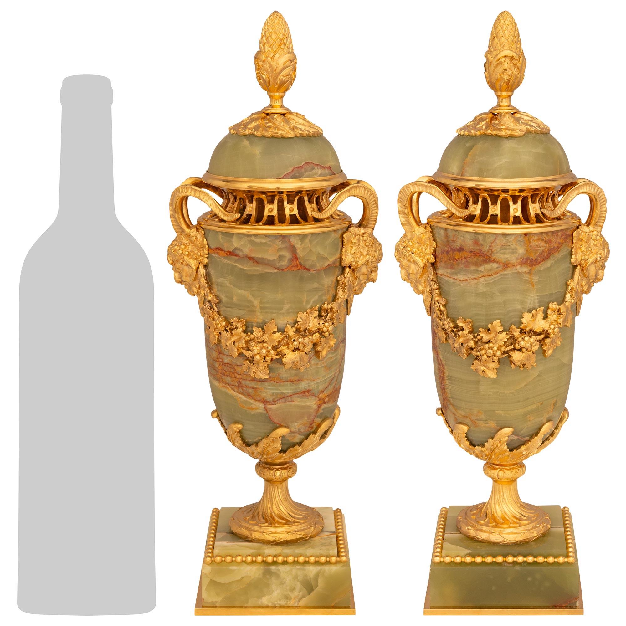 Una coppia elegante e di alta qualità di urne in onice e ormolu francesi del XIX secolo in stile Luigi XVI. Ogni eccezionale urna con coperchio è sollevata da una solida base quadrata in Onice su un supporto inferiore in Ormolu e un bordo superiore