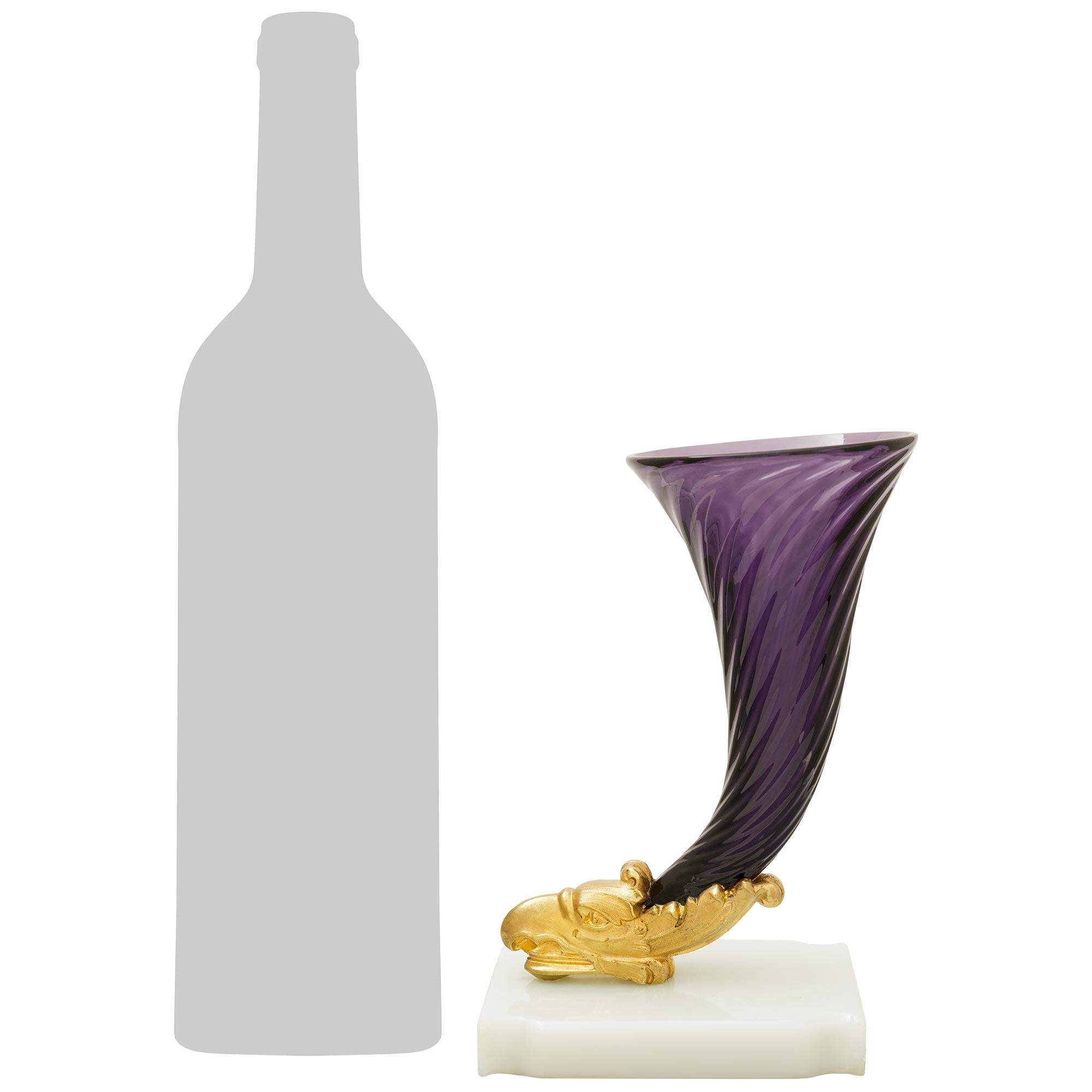 Un'impressionante coppia di vasi francesi del XIX secolo in onice, ormolu e vetro. Ogni elegantissimo vaso a forma di cornucopia è sostenuto da una base rettangolare in onice color crema con angoli smerlati. In cima alla base in onice c'è una testa