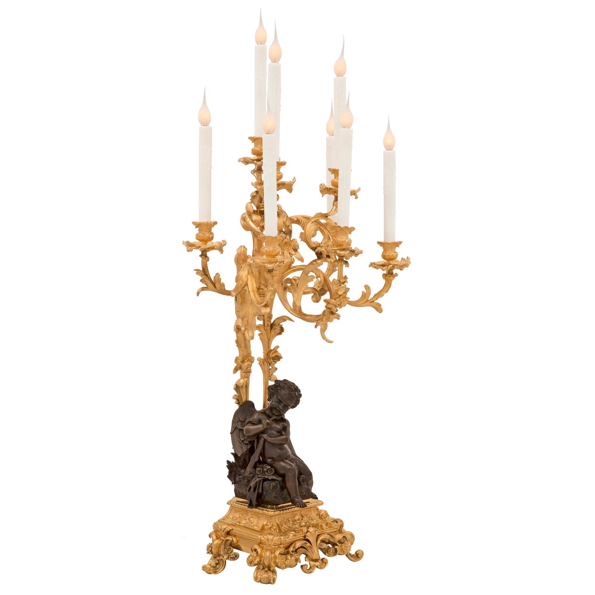 A stunning and extremely high quality true pair of French 19th century Louis XVI st. ormolu and patinated bronze candelabra lamps. Each eight arm lamp is raised by a stunning wonderfully executed base with luxuriant scrolled foliate designs,