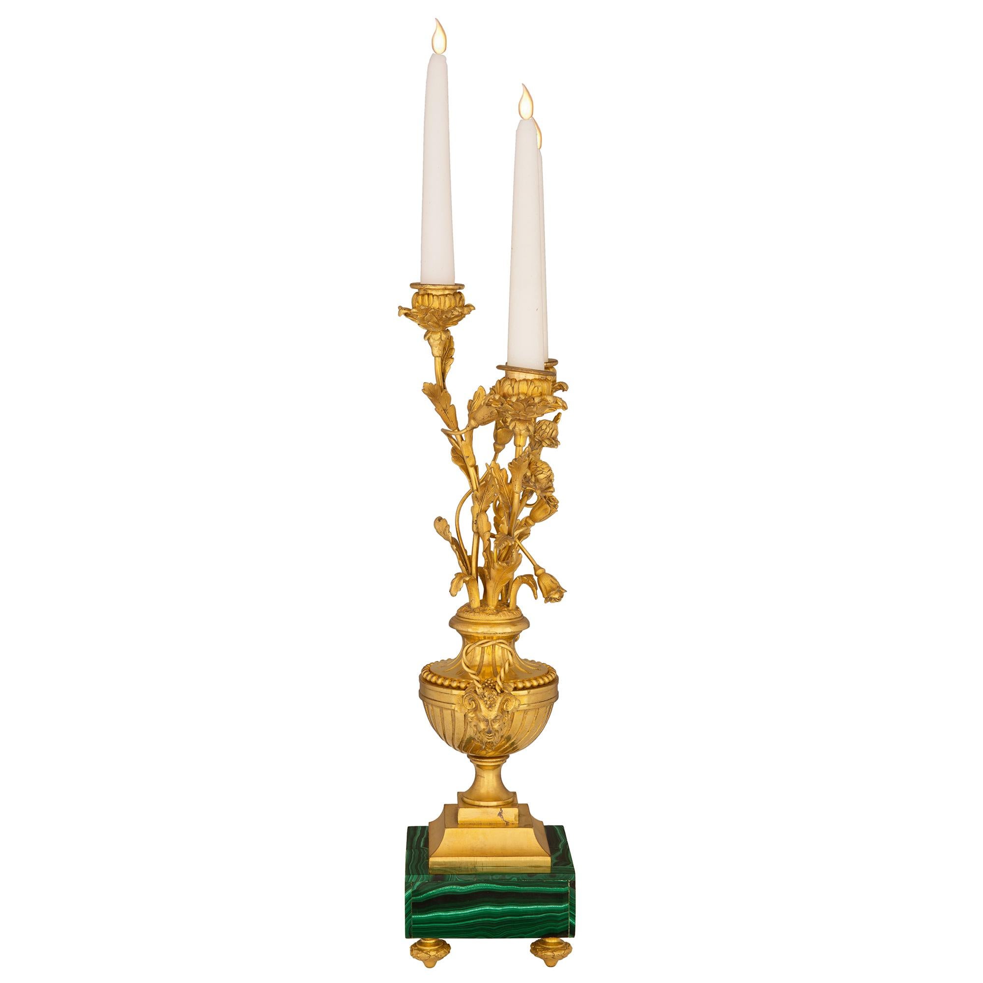 An outstanding and high quality pair of French mid 19th century Louis XVI st. ormolu and Malachite three arm candelabras. Each candelabra is raised by a square Malachite base with fine topie shaped ormolu feet. The square shaped stepped central