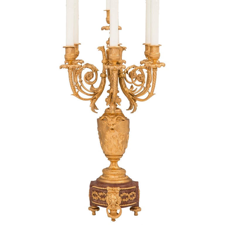 A stunning pair of French 19th century Louis XVI st. ormolu and Rouge marble candelabra lamps attributed to Barbedienne and after a model by John Flaxman. Each seven arm lamp is raised by most elegant topie shaped feet below the Rouge marble base.