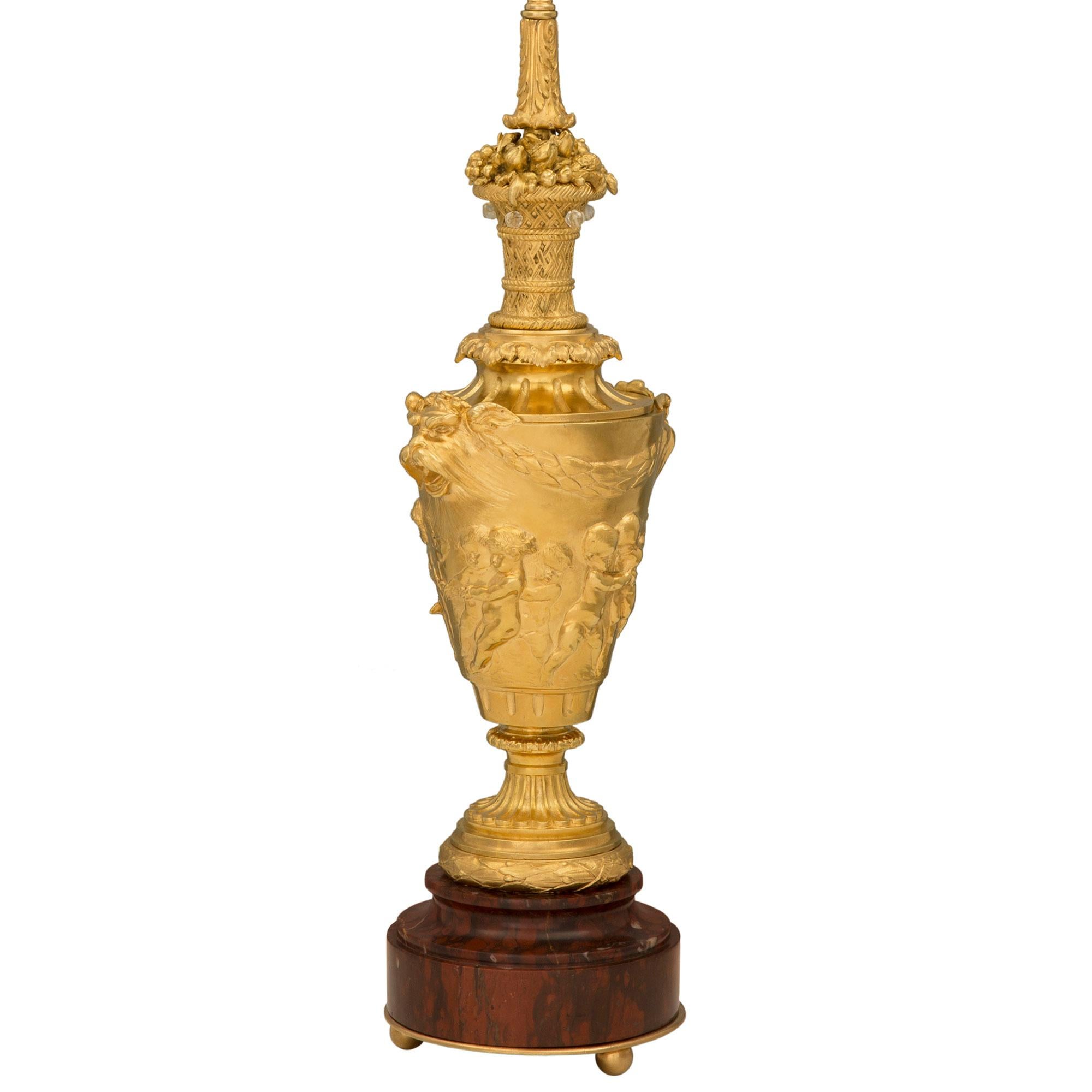 Paire de lampes en marbre Rouge Griotte et bronze doré de style Louis XVI du 19ème siècle, attribuée à Barbedienne et d'après un modèle de John Flaxman. Chaque lampe est surélevée par une impressionnante base circulaire en marbre Rouge Griotte avec