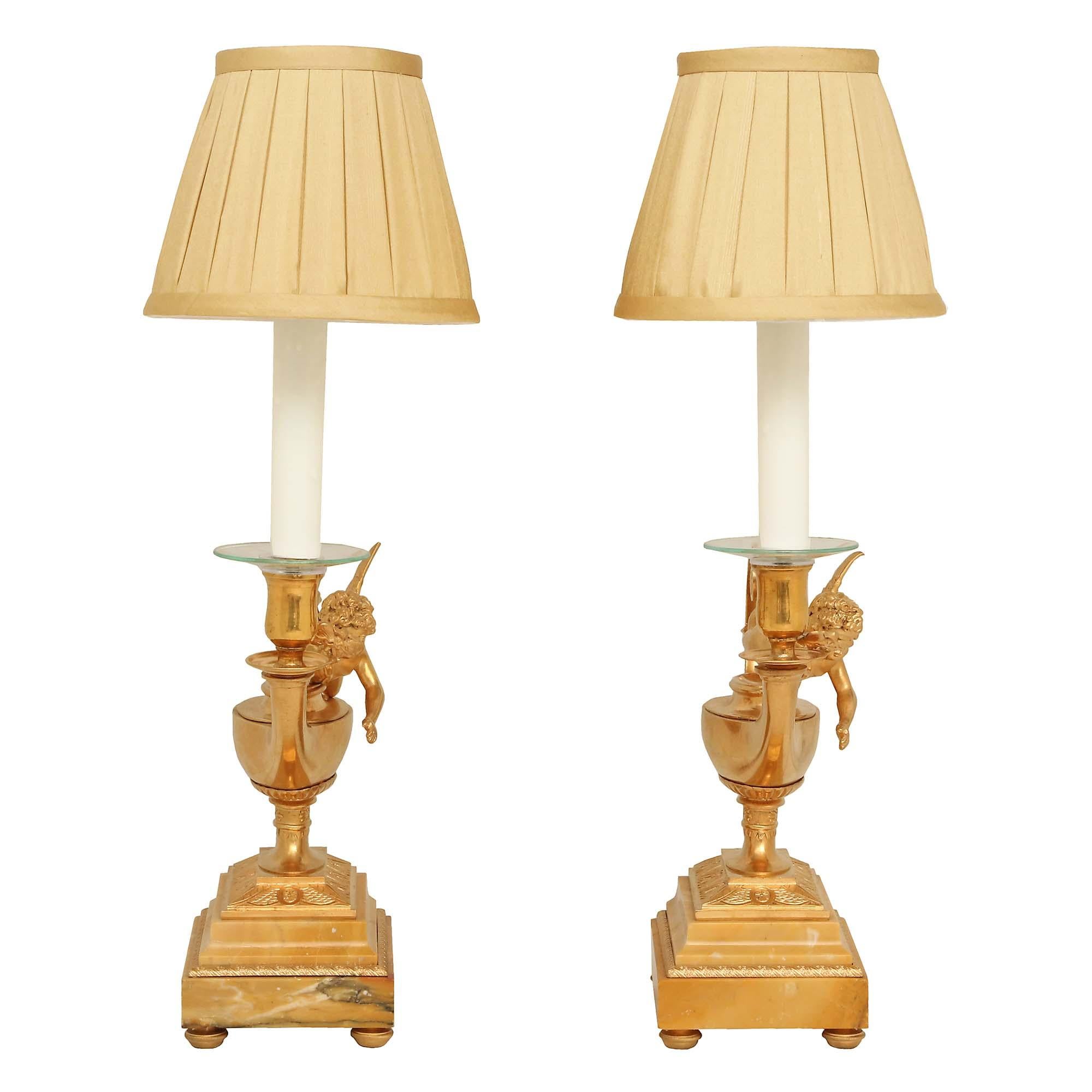 A superb pair of French 19th century Louis XVI st. ormolu and marble lamps. Raised on ormolu bun feet below a rectangular sienna marble base with chased ormolu trim. Above each is a raised platform with foliate chasings supporting the ormolu oil