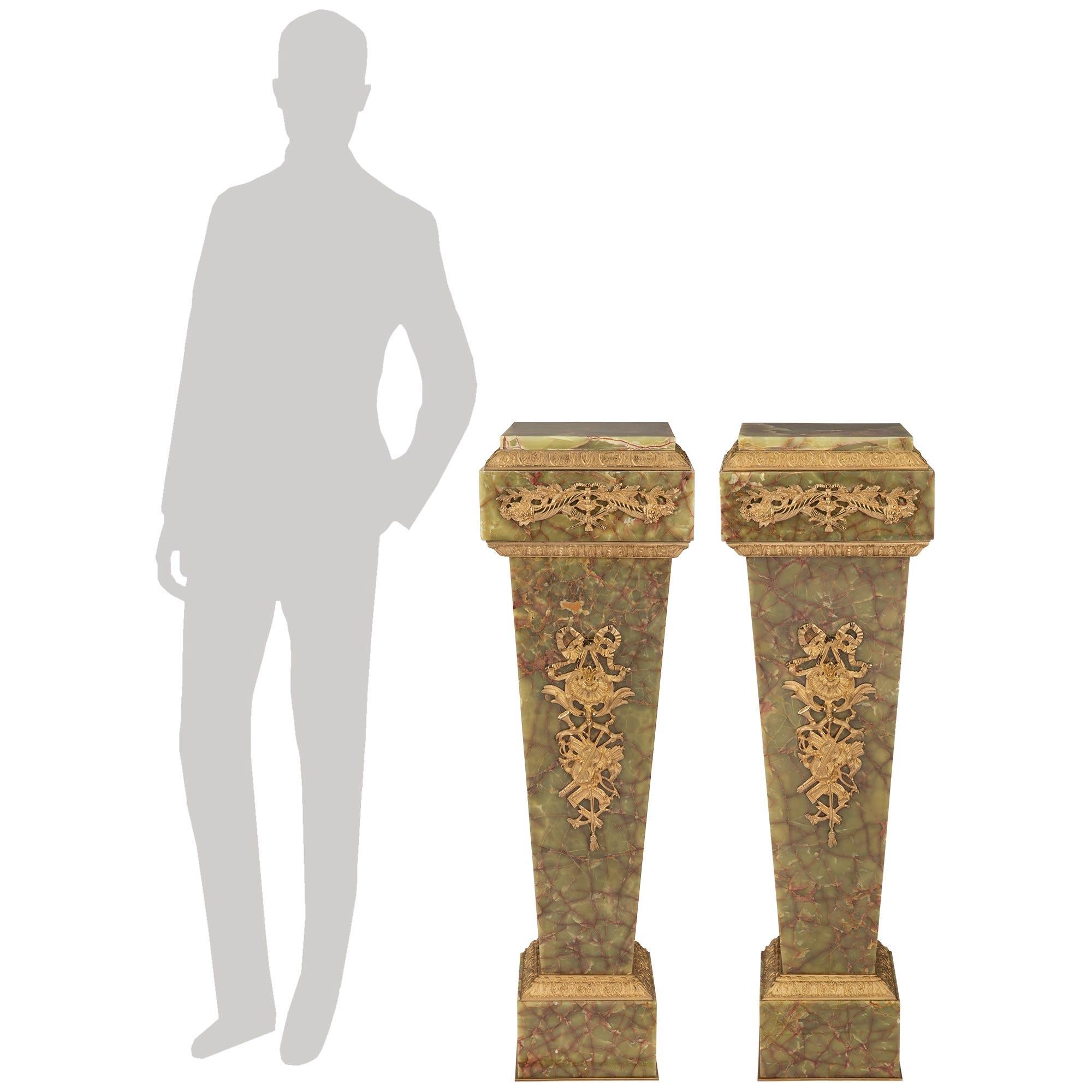 A sensational and high quality pair of French 19th century Louis XVI st. Ormolu and Onyx pedestals. Each stunning pedestal is raised by a square base with a fine bottom and top foliate Ormolu bands. The square tapered central supports display