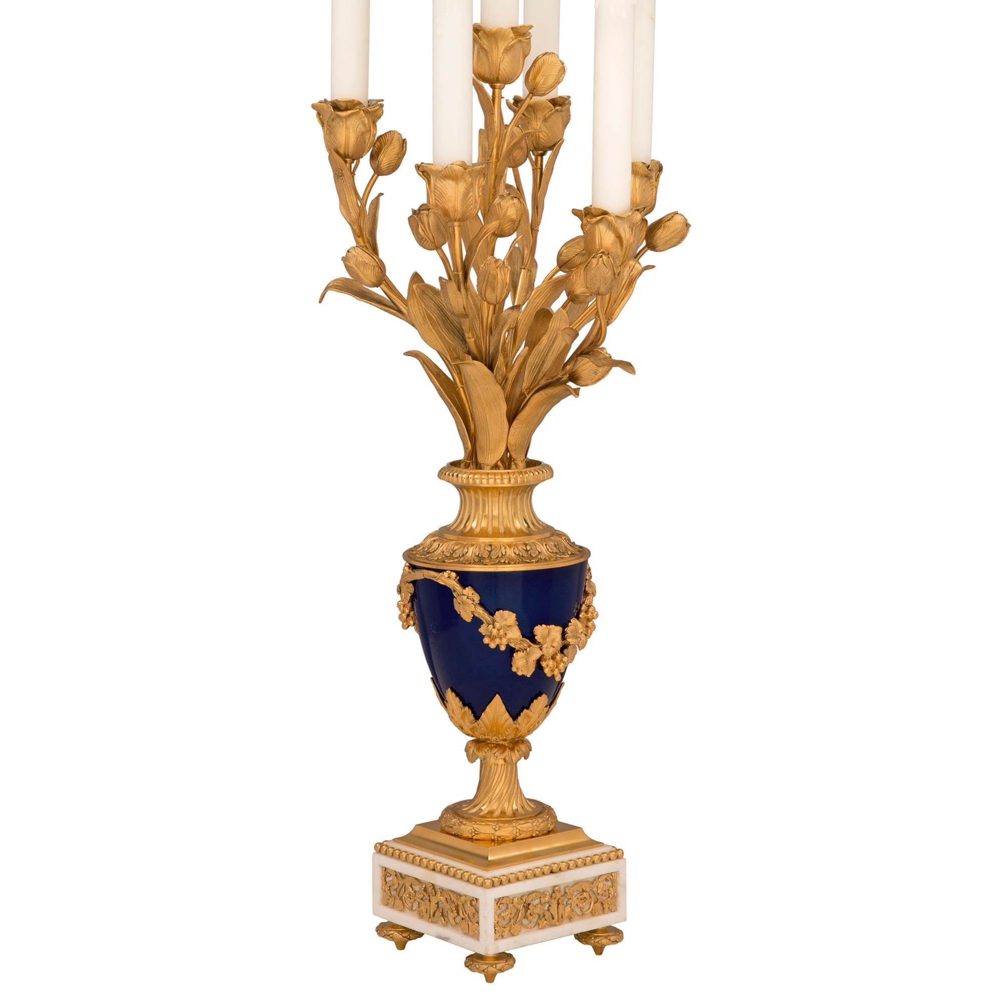 An exquisite pair of French 19th century Louis XVI st. white Carrara marble, ormolu and Sèvres porcelain candelabra lamps. Each six arm lamp is raised by elegant topie shaped feet below a square white Carrara marble base decorated with exceptional