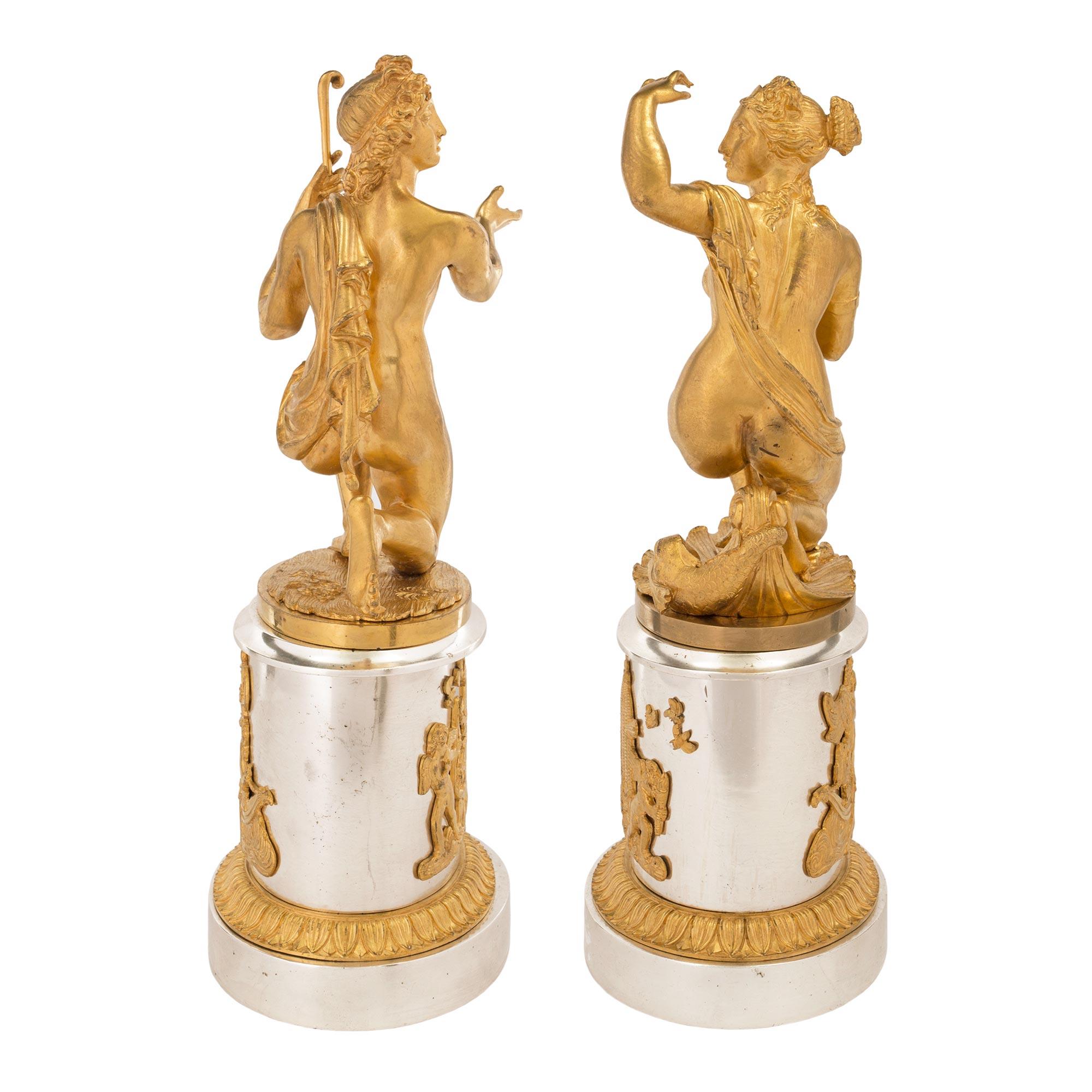 An elegant and high quality true pair of French 19th century Louis XVI st. ormolu and silvered bronze statues. Each statue is raised by silvered bronze oval bases with Fine mottled foliate ormolu bands and strikingly decorative and extremely