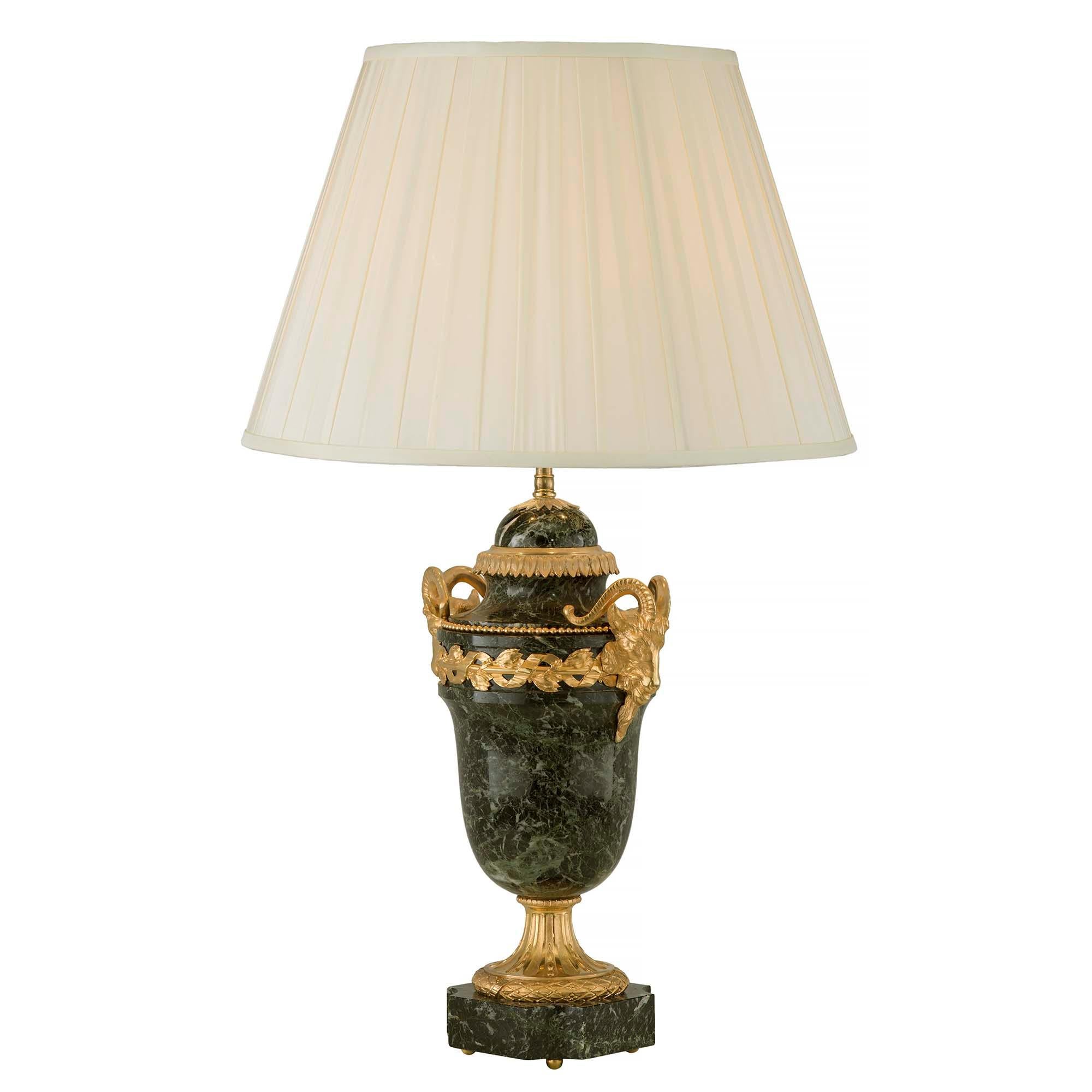 An elegant pair of French 19th century Louis XVI st. ormolu and Vert antique marble lamps. Each lamp is raised on ormolu ball feet below the marble base with concave corners. The richly chased satin and burnished finished socle pedestal with a