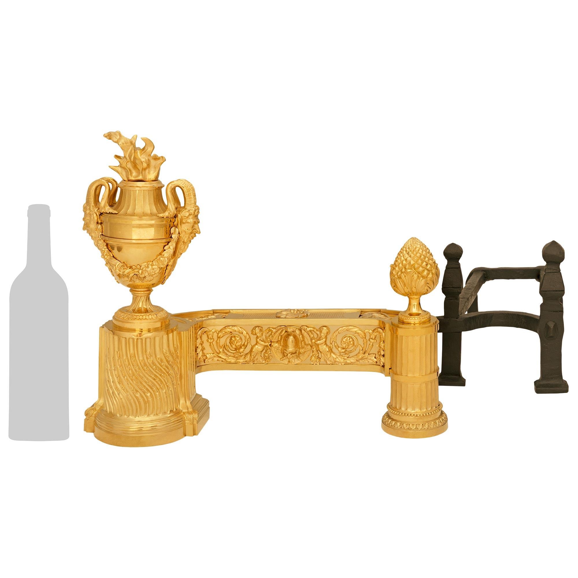 Un'imponente ed elegante coppia di androni francesi del XIX secolo in stile Luigi XVI in ormolu e ferro battuto. Ogni eccezionale ferro da stiro è sollevato da una colonna scanalata a spirale, decorata con candele, che sostiene un'urna di prosperità