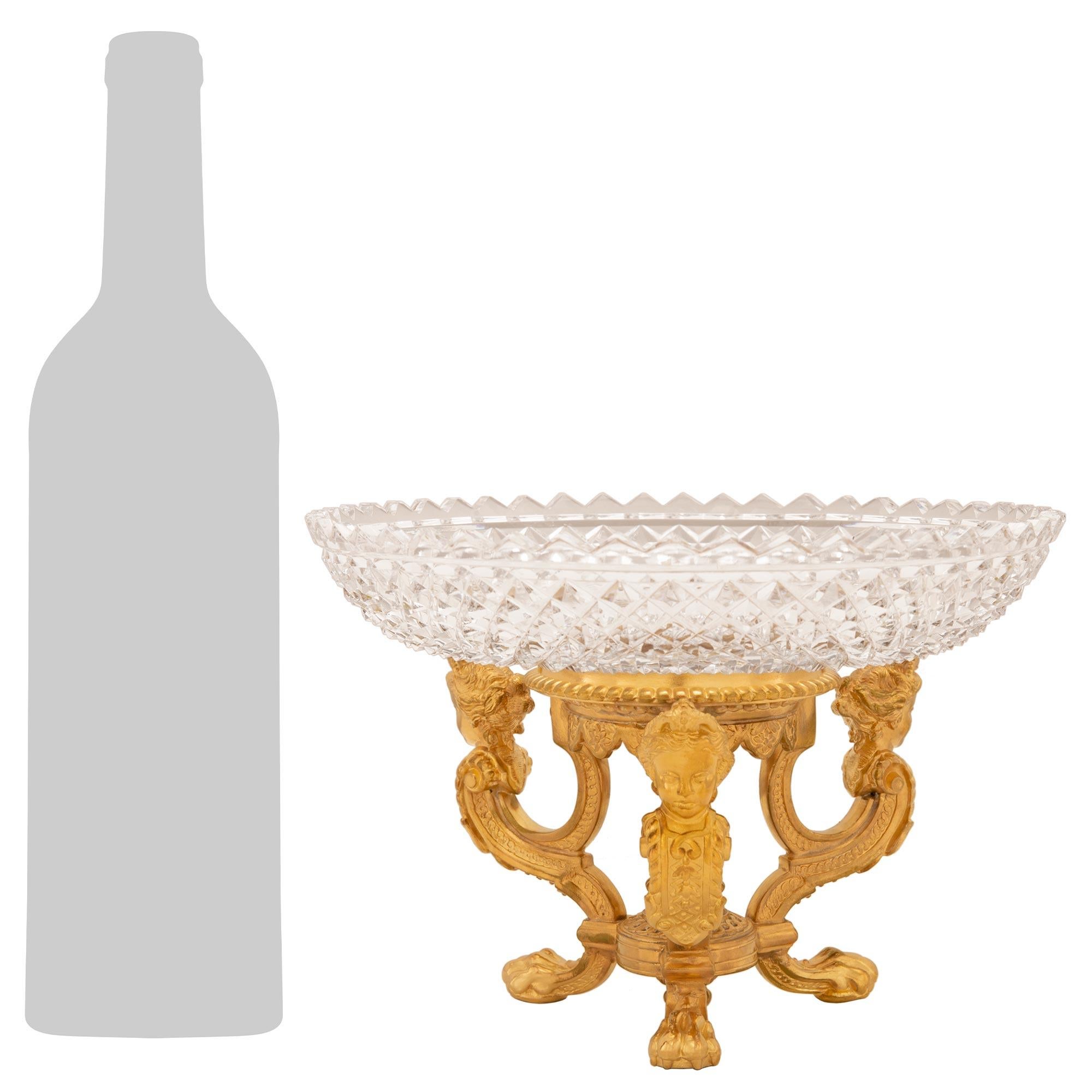 A striking and most elegant pair of French 19th century Louis XVI st. ormolu and Baccarat crystal centerpieces. Each centerpiece is raised by three beautifully scrolled supports with handsome paw feet and lovely interlocking geometric bands leading