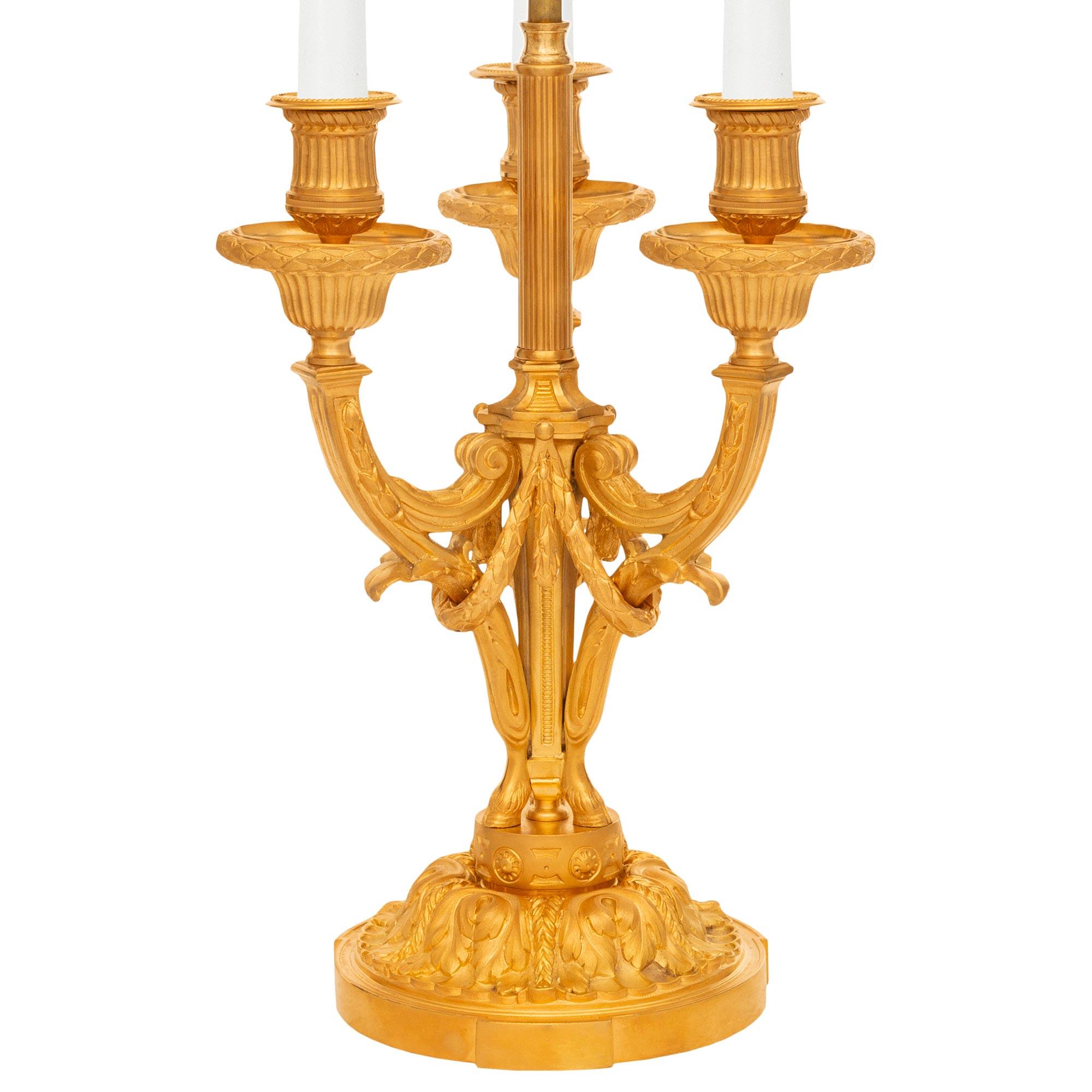 A very attractive pair of French 19th century Louis XVI st. Ormolu Bouillotte candelabra lamps. Each lamp is raised on a circular Ormolu base with finely chased acanthus leaves below a circular pedestal decorated on all sides by rosettes. The three