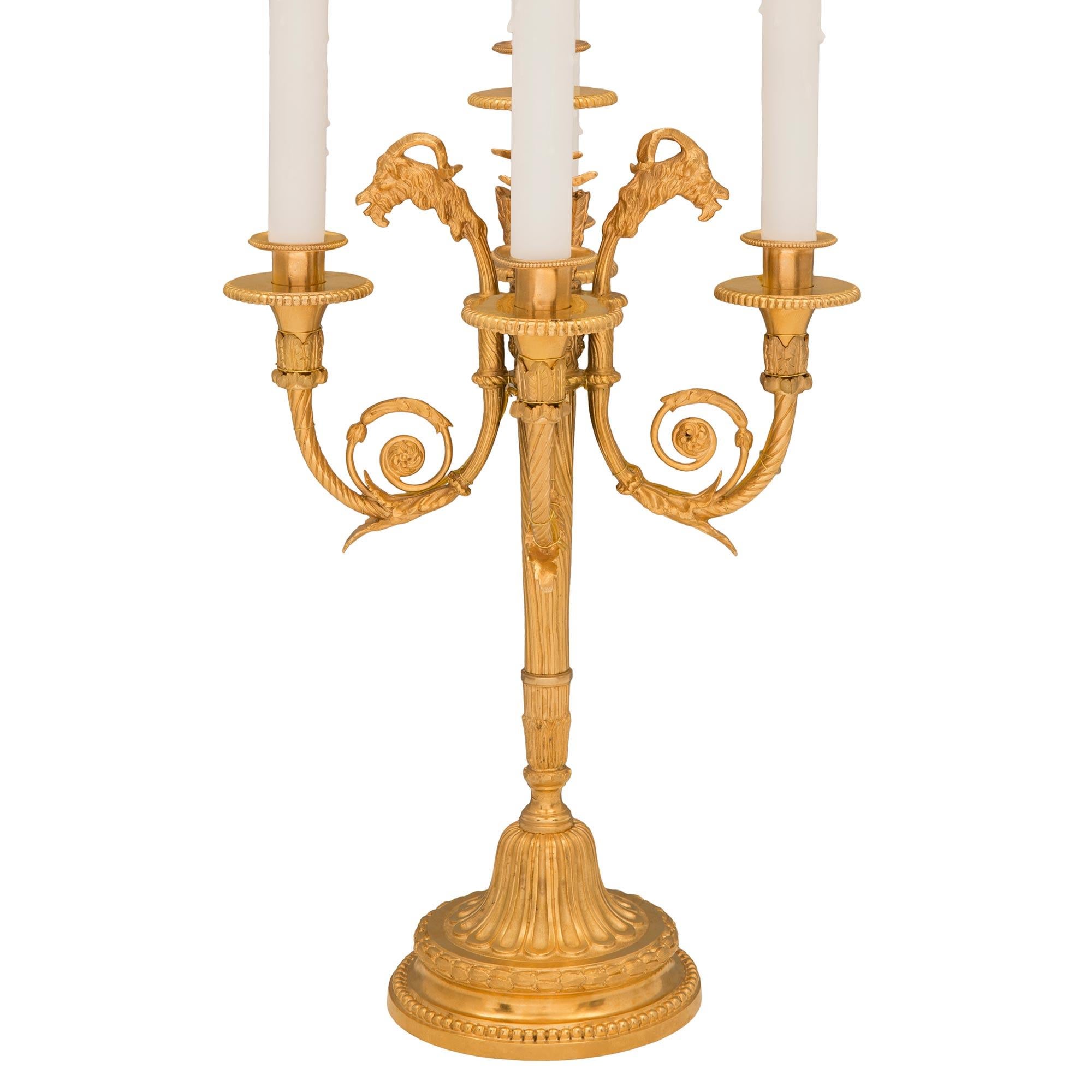 A most elegant pair of French 19th century Louis XVI st. ormolu candelabra lamps. Each five arm lamp is raised by a circular mottled base with a fine beaded and richly chased berried laurel wrap around bands. The socle shaped pedestal supports