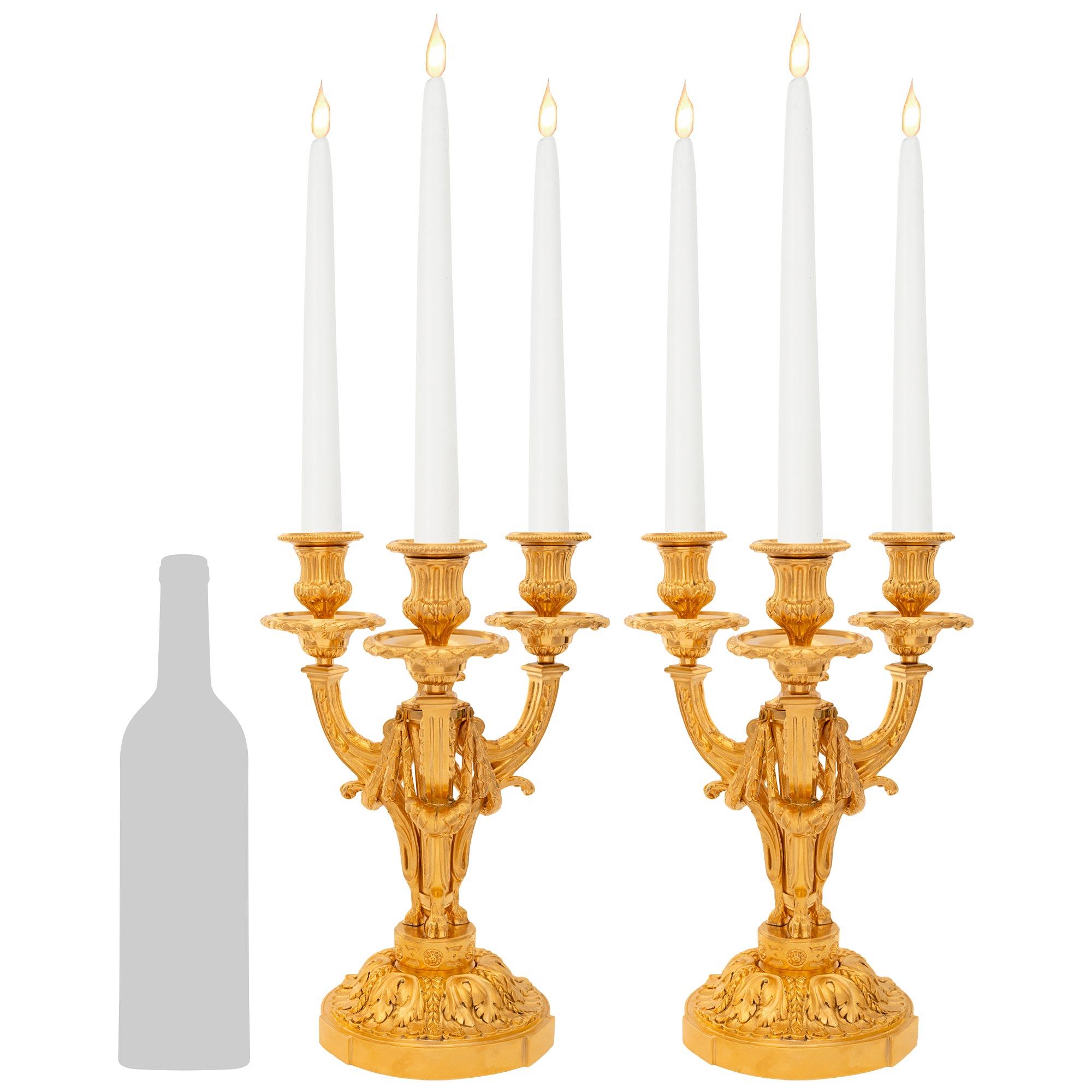 An elegant and most attractive pair of French 19th century Louis XVI st. Ormolu candelabras. Each three arm candelabra is raised on a circular Ormolu base with finely chased acanthus leaves below a circular pedestal decorated on all sides by