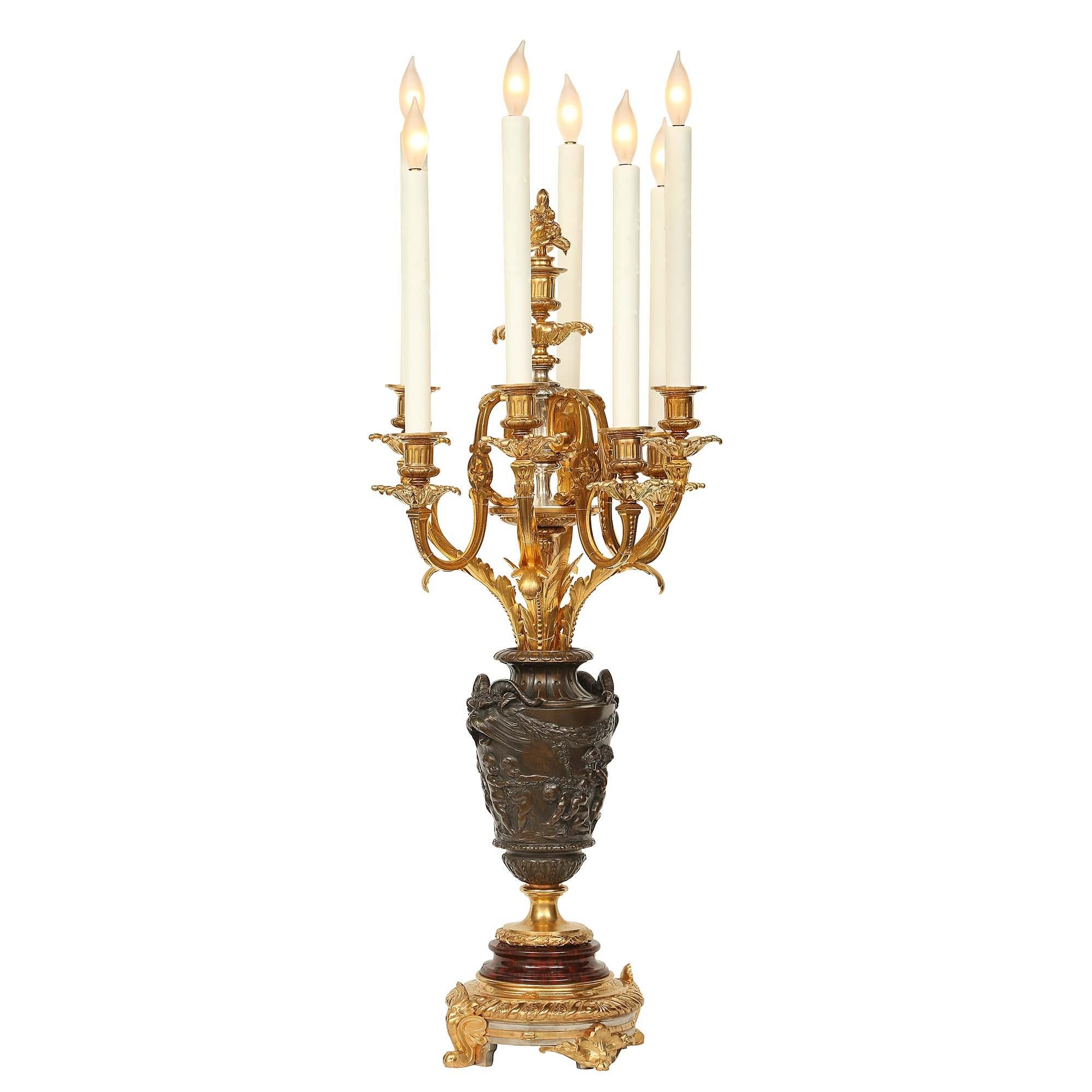 An exquisite pair of 19th century Louis XVI st. ormolu candelabras, attributed to F. Barbedienne. Each candelabra is raised on a circular finely chased ormolu base with acanthus leaf styled supports. Above is a moulded Rouge Griotte base below the