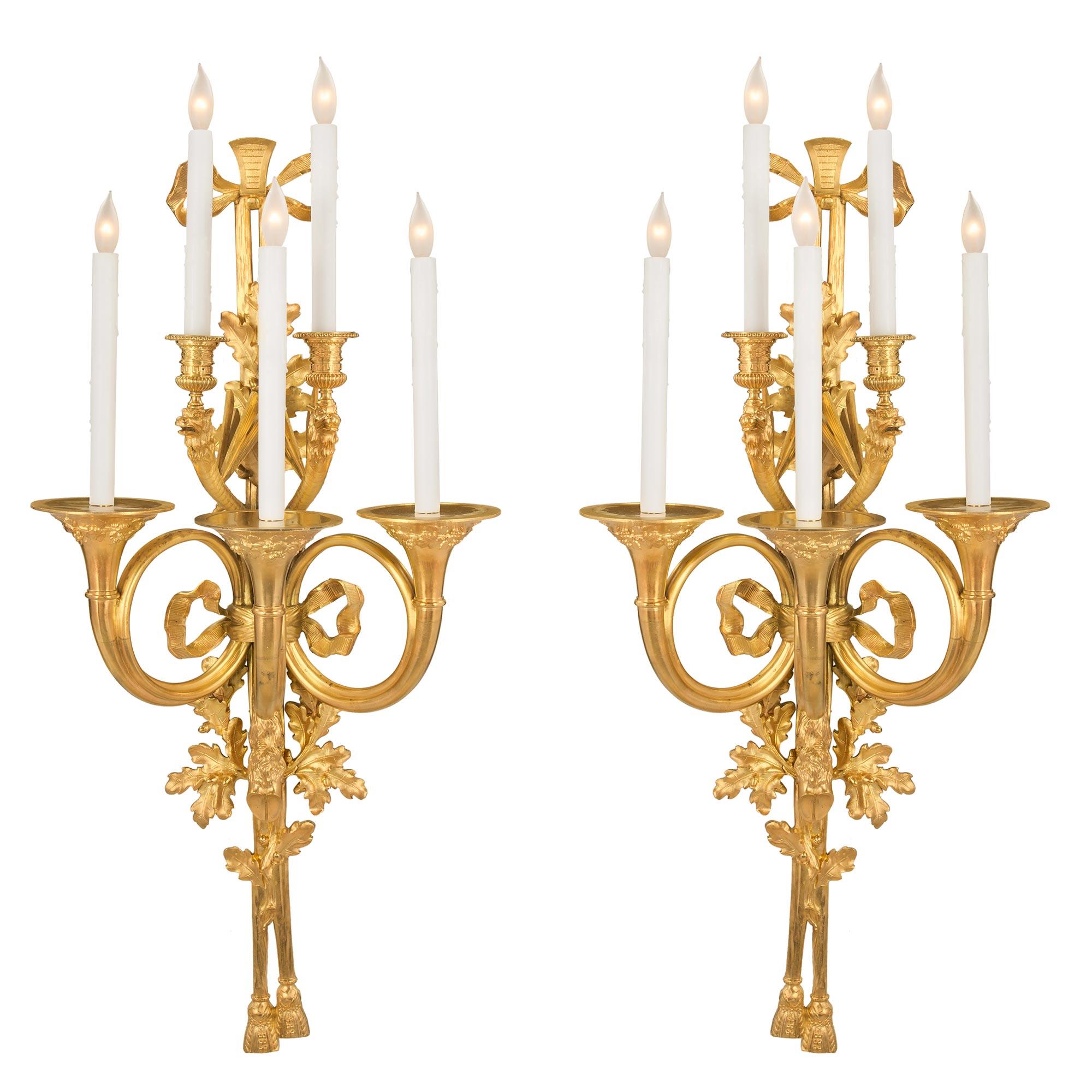 A stunning and most impressive pair of French 19th century Louis XVI St. ormolu five-arm sconces. Modeled after a pair by the bronzier Claude Galle which he created in 1809, for the 'Grand Salon of Le Petit Trianon