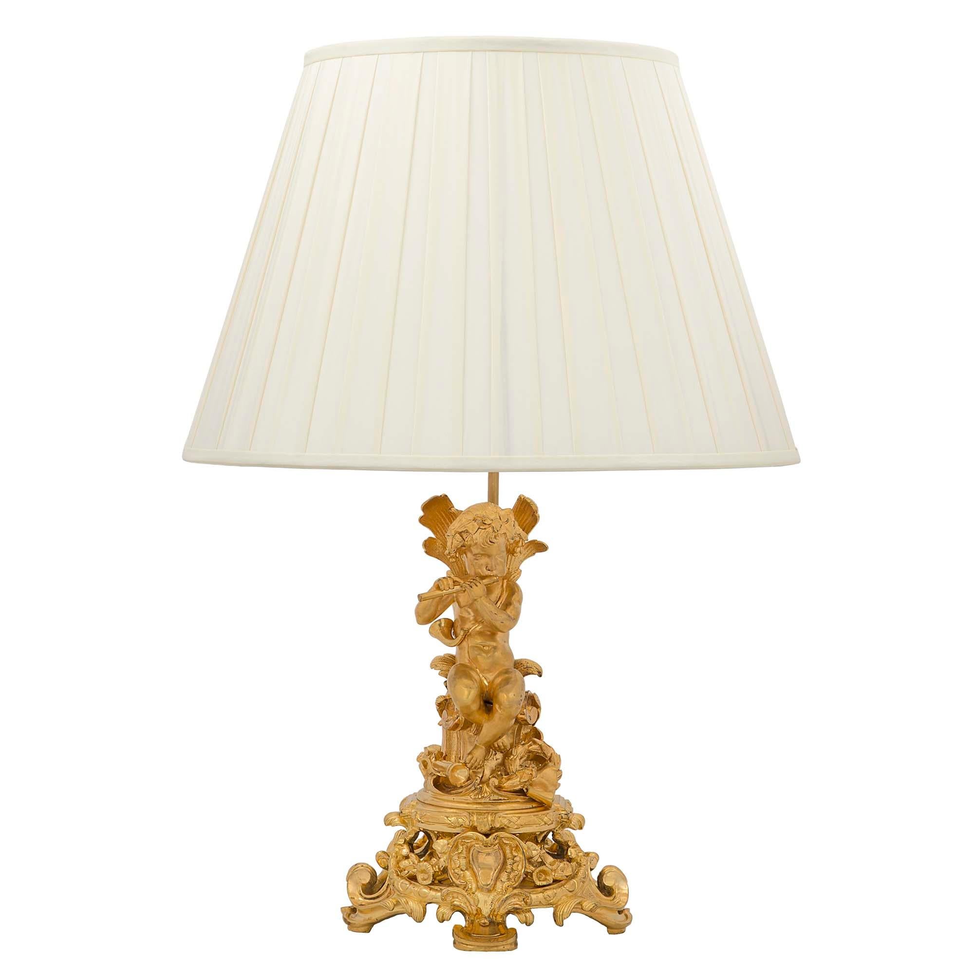 Une belle paire de lampes en bronze doré de style Louis XVI du 19ème siècle. Chaque lampe est surélevée par une base à volutes percées très décorative avec un cabochon central. Au-dessus se trouvent de charmants chérubins assis sur un tronc d'arbre