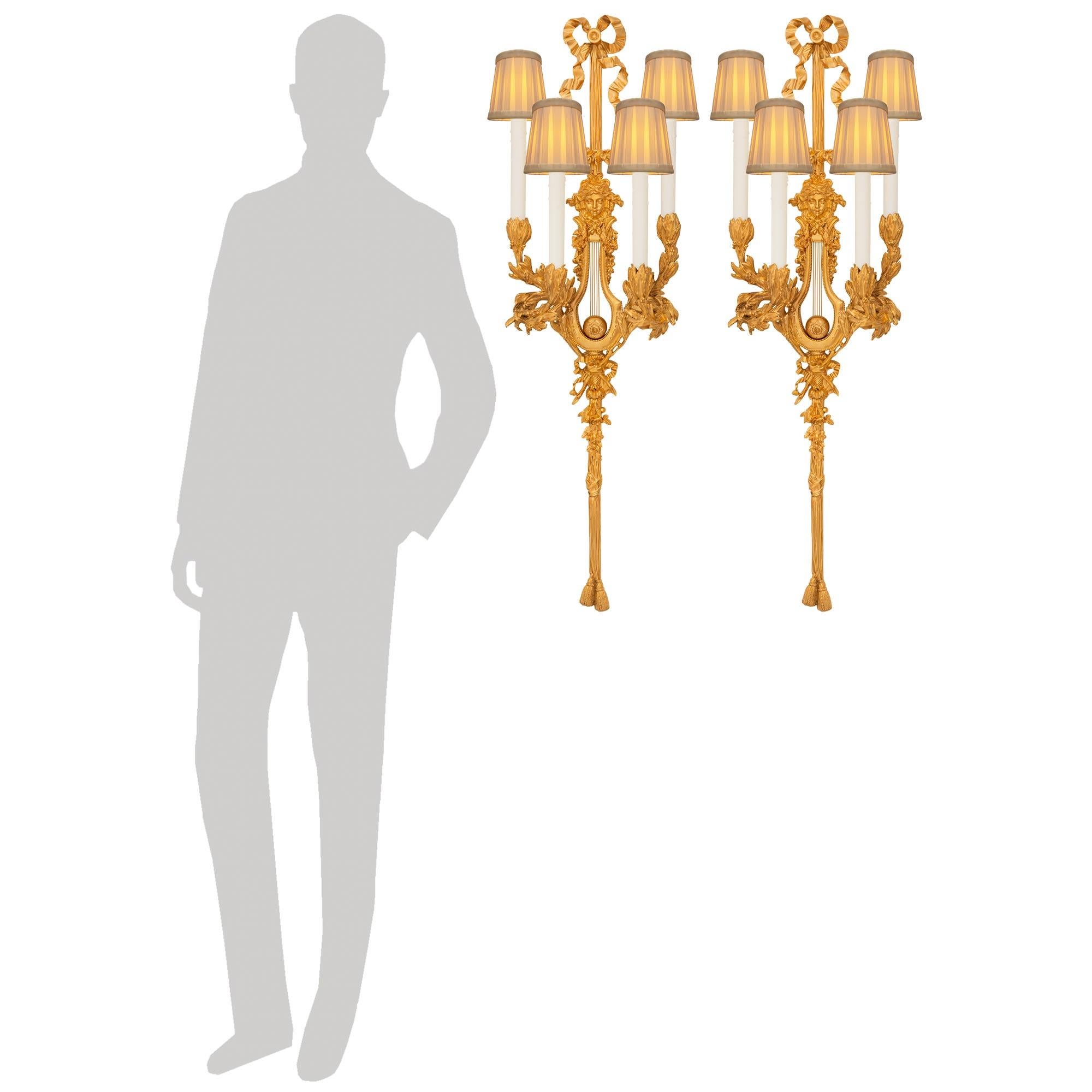 Un'elegante coppia di appliques francesi del XIX secolo in stile Luigi XVI. Ciascuna bellissima applique è stata realizzata su modello di Pierre Gouthière e presenta bracci a voluta che mostrano motivi fogliacei con bacche e sono ornati da nappe