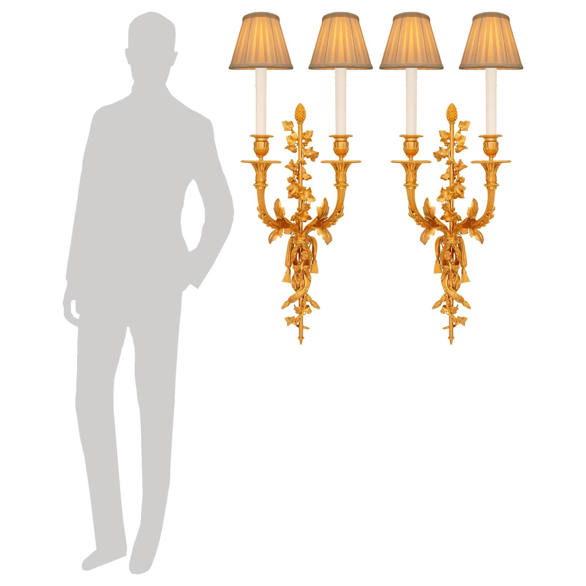Una coppia elegante e di alta qualità di appliques francesi del XIX secolo in stile Luigi XVI. Ciascuna meravigliosa applique a due bracci è centrata da un fut centrale dritto con un terminale inferiore a forma di topie e una corona superiore a