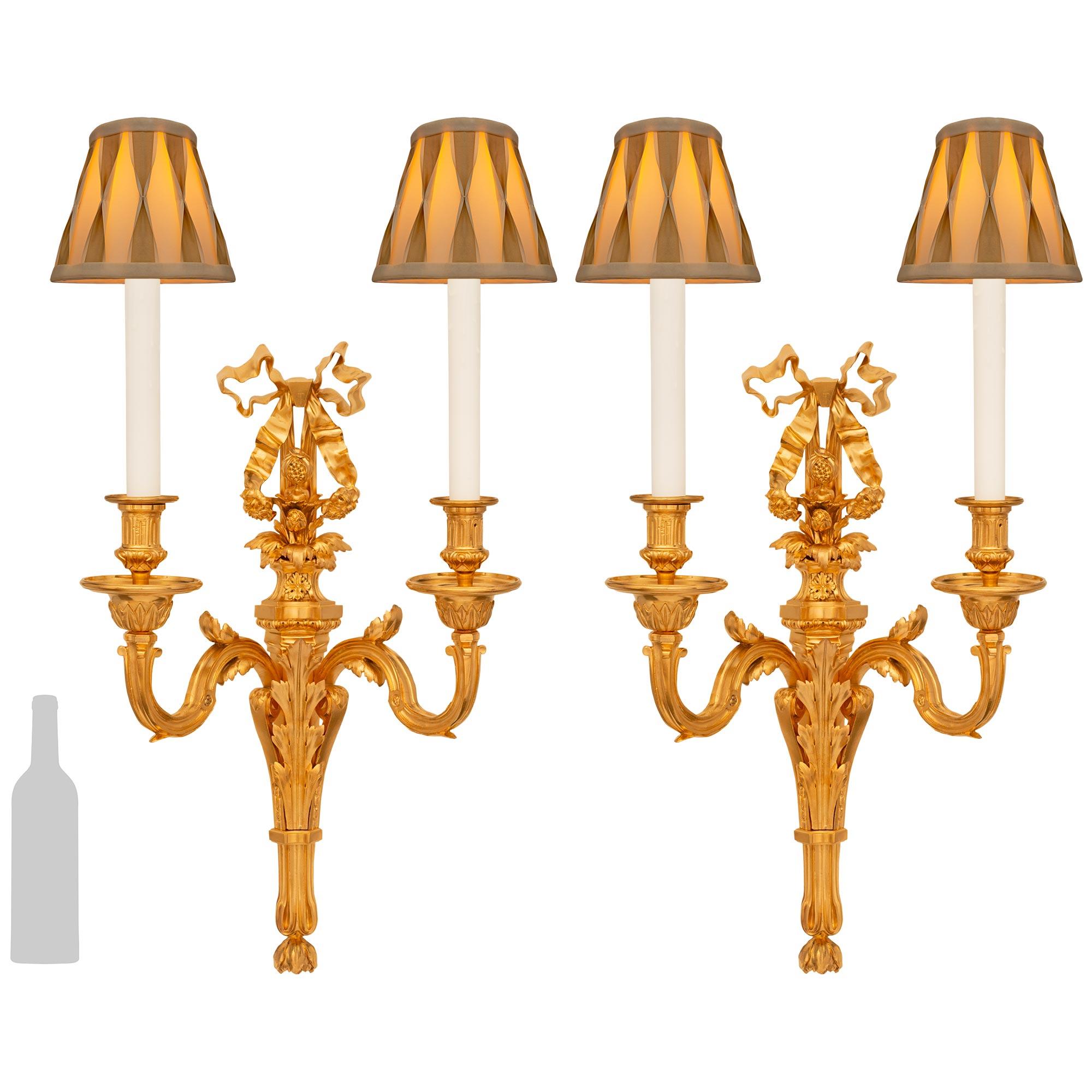 Preciosa y elegantísima pareja de apliques franceses de Ormolu del siglo XIX, estilo Luis XVI, firmados Sormani. Cada candelabro de dos brazos está centrado por una elegante placa posterior cónica con un fino remate inferior foliado y llamativas