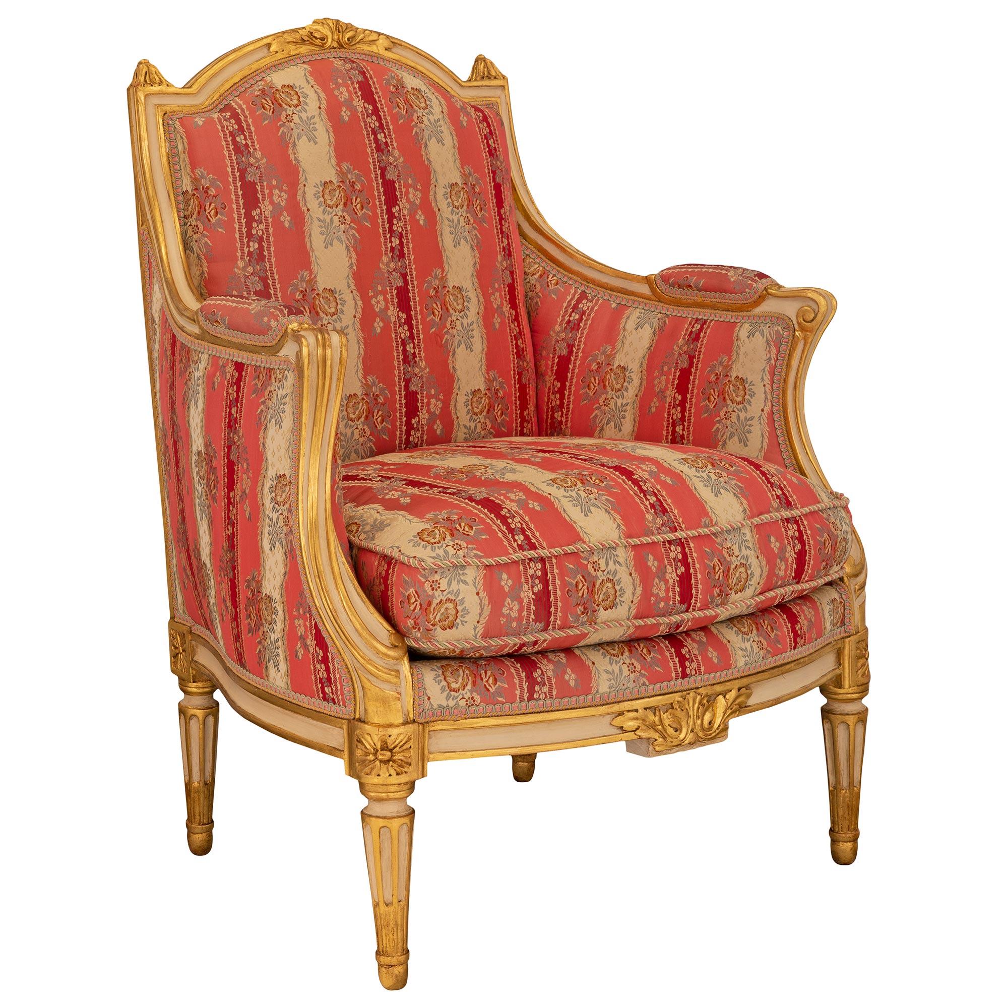 An exceptional and most elegant pair of French 19th century Louis XVI st. patinated and giltwood armchairs. Each armchair is raised by circular tapered fluted legs with fine mottled feet and richly carved corner block rosettes. The apron displays a