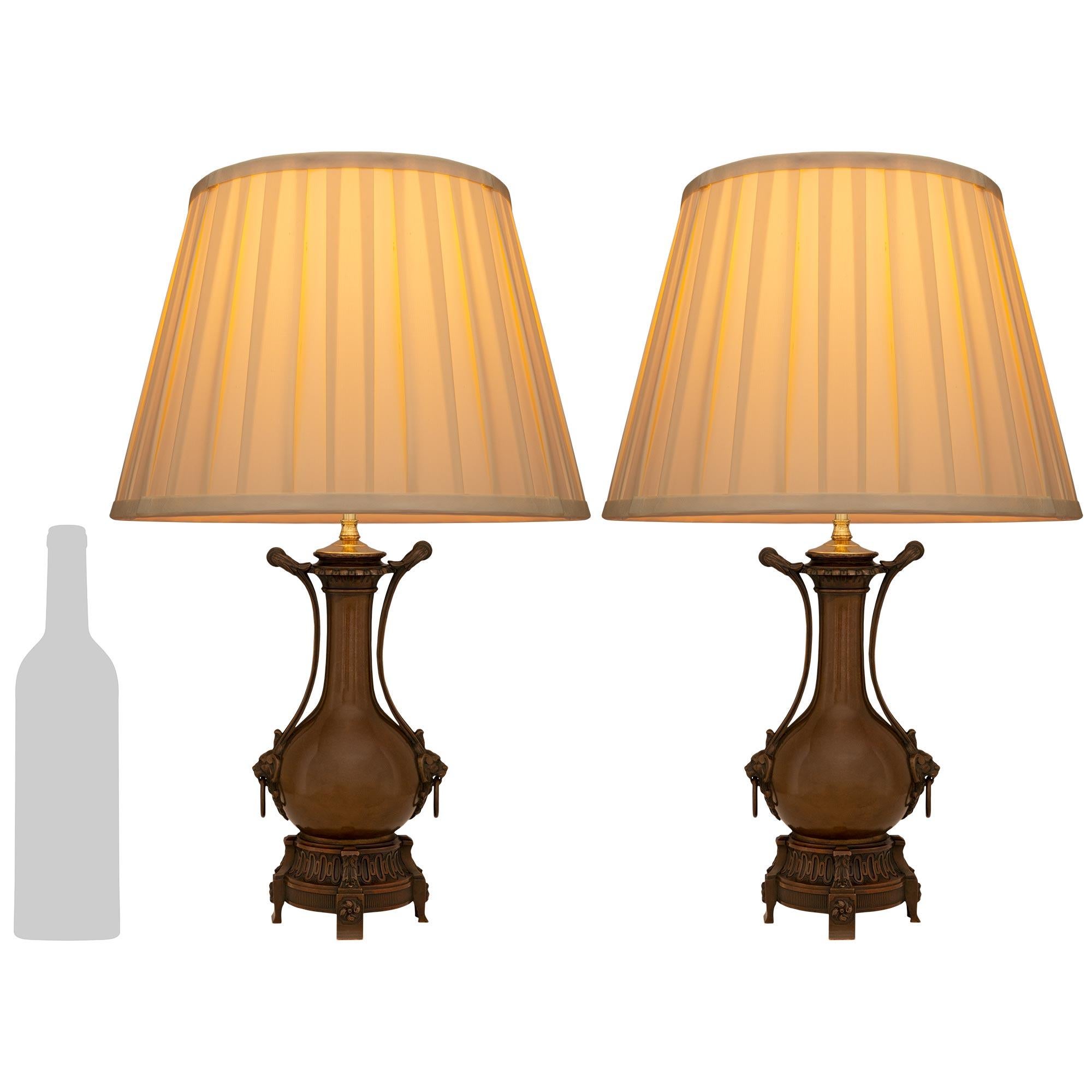 Une belle et très élégante paire de lampes en bronze patiné de style Louis XVI du XIXe siècle. Chaque lampe à huile électrifiée est surmontée d'une base circulaire ornée de motifs de cannelures et de denticules et repose sur quatre pieds en bloc