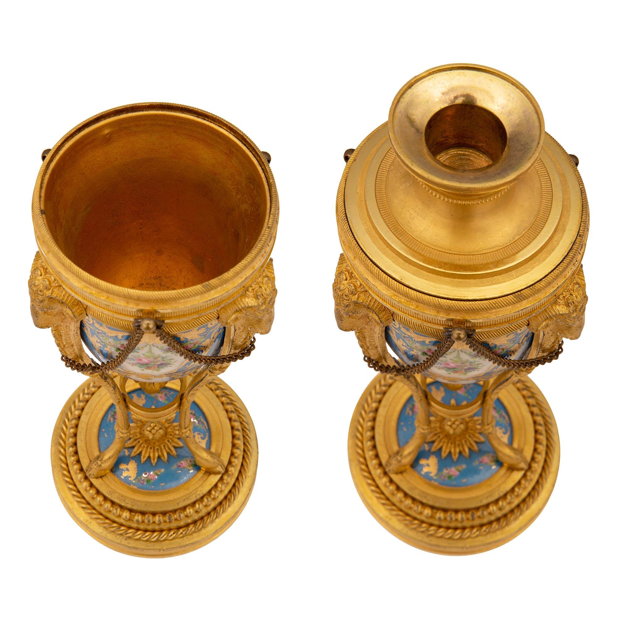 An extremely elegant pair of French 19th century Louis XVI st. Sèvres porcelain and ormolu cassolettes. Each cassolette is raised by a circular ormolu base with a stepped design, fitted twisted ribbon and beaded ormolu bands. At the bottom is a