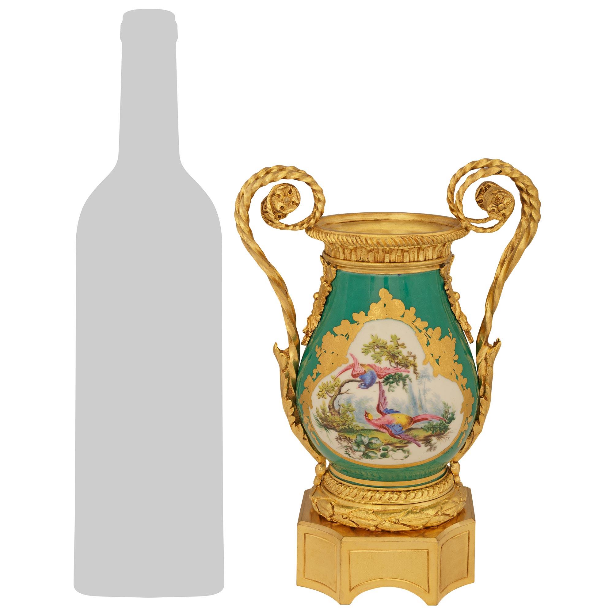 Una deliziosa ed elegantissima coppia di urne in porcellana di Sévres e ormolu del XIX secolo. Ogni splendida urna è sollevata da un alto basamento quadrato in Ormolu con angoli tagliati che sorregge una corona di alloro con bacche e uno zoccolo a