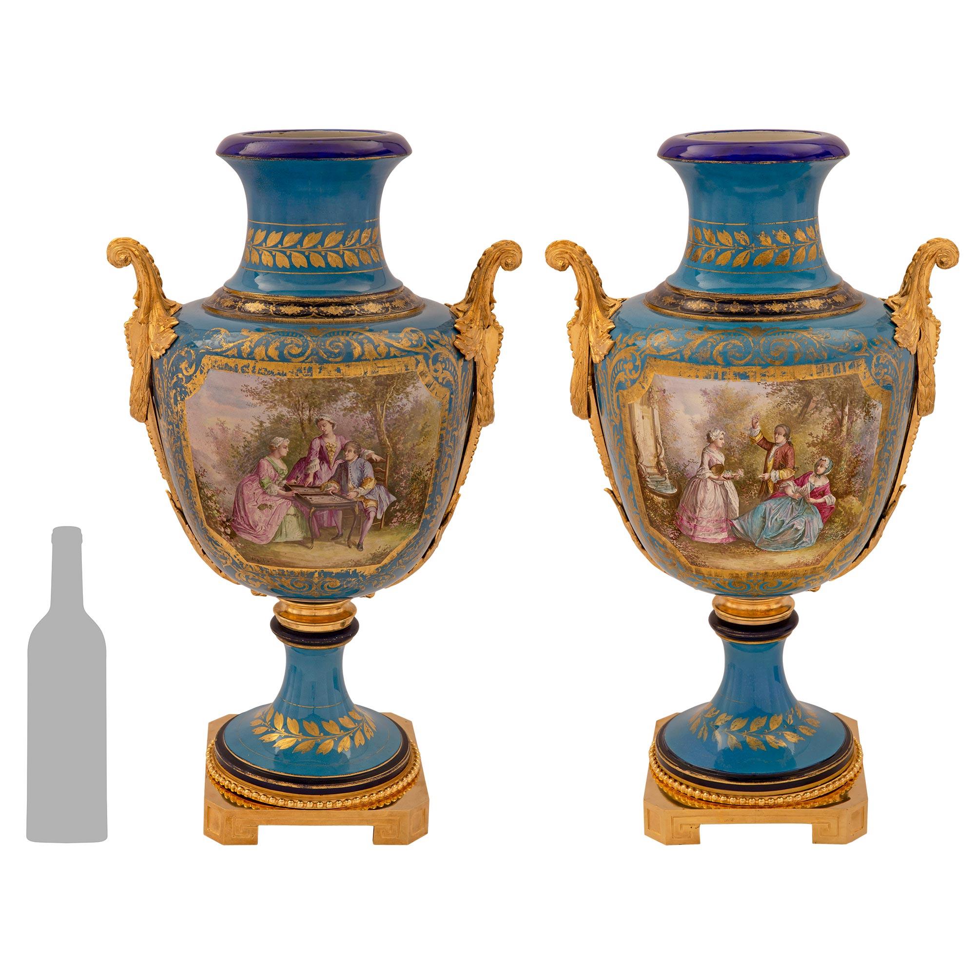 Une paire impressionnante et de grande taille de vases en porcelaine et bronze doré de Sèvres de style Louis XVI du 19ème siècle, signés par Sèvres. Chaque vase est surélevé par une élégante base carrée en bronze doré aux angles coupés et aux motifs