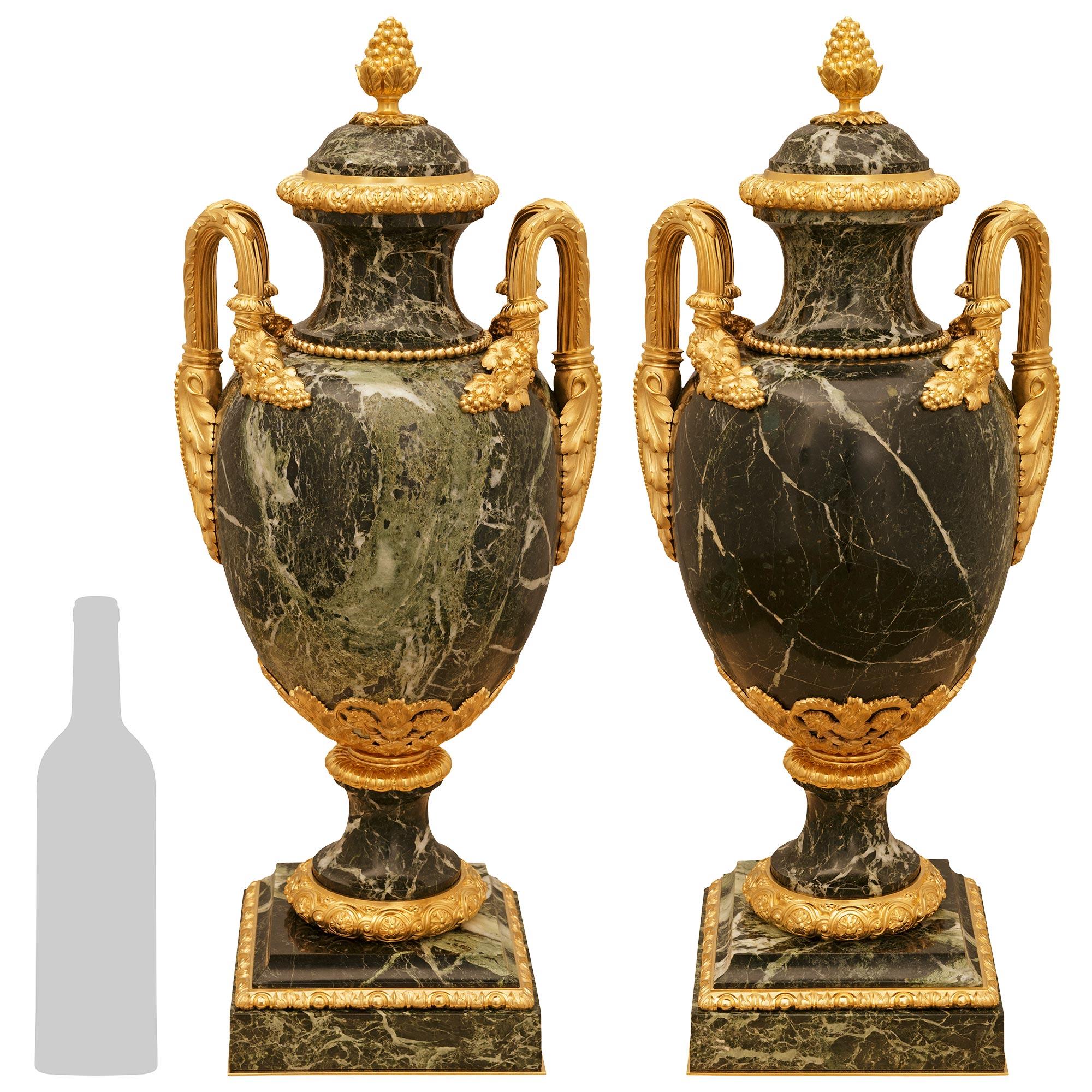 Una coppia elegante e di alta qualità di urne francesi del XIX secolo in marmo Verde Antico e Ormolu, alla maniera della Maison Brisk One. Ciascuna urna è sollevata da una base quadrata in marmo Verde Antico con fasce foliate in Ormolu che sostiene