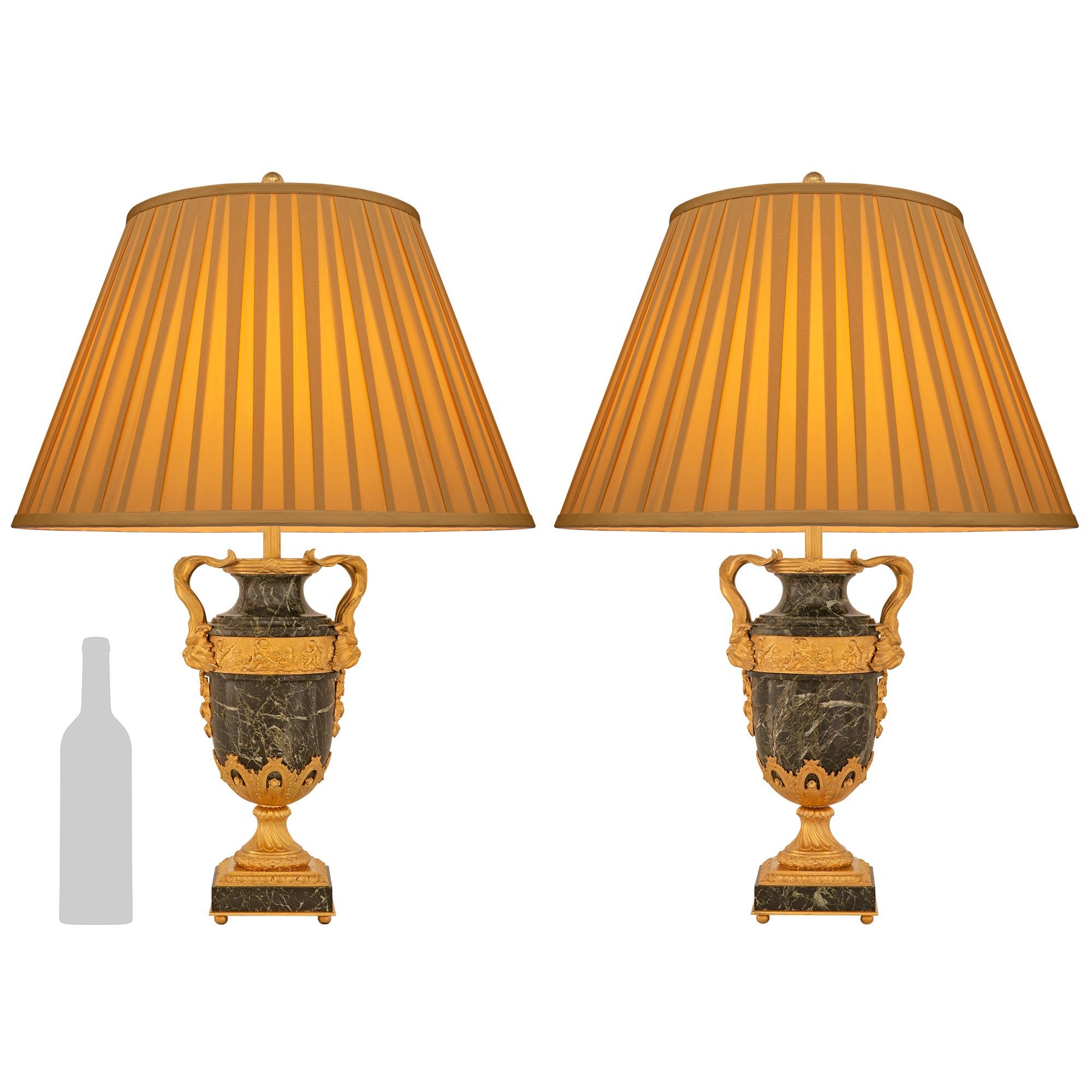 Splendida coppia di lampade francesi del XIX secolo in marmo e ormeggio Vert Patricia. Ogni lampada è sollevata su piedi a sfera in ormeggio sotto il supporto quadrato in marmo e ormeggio. La base scanalata in ormolu è ornata da una corona di