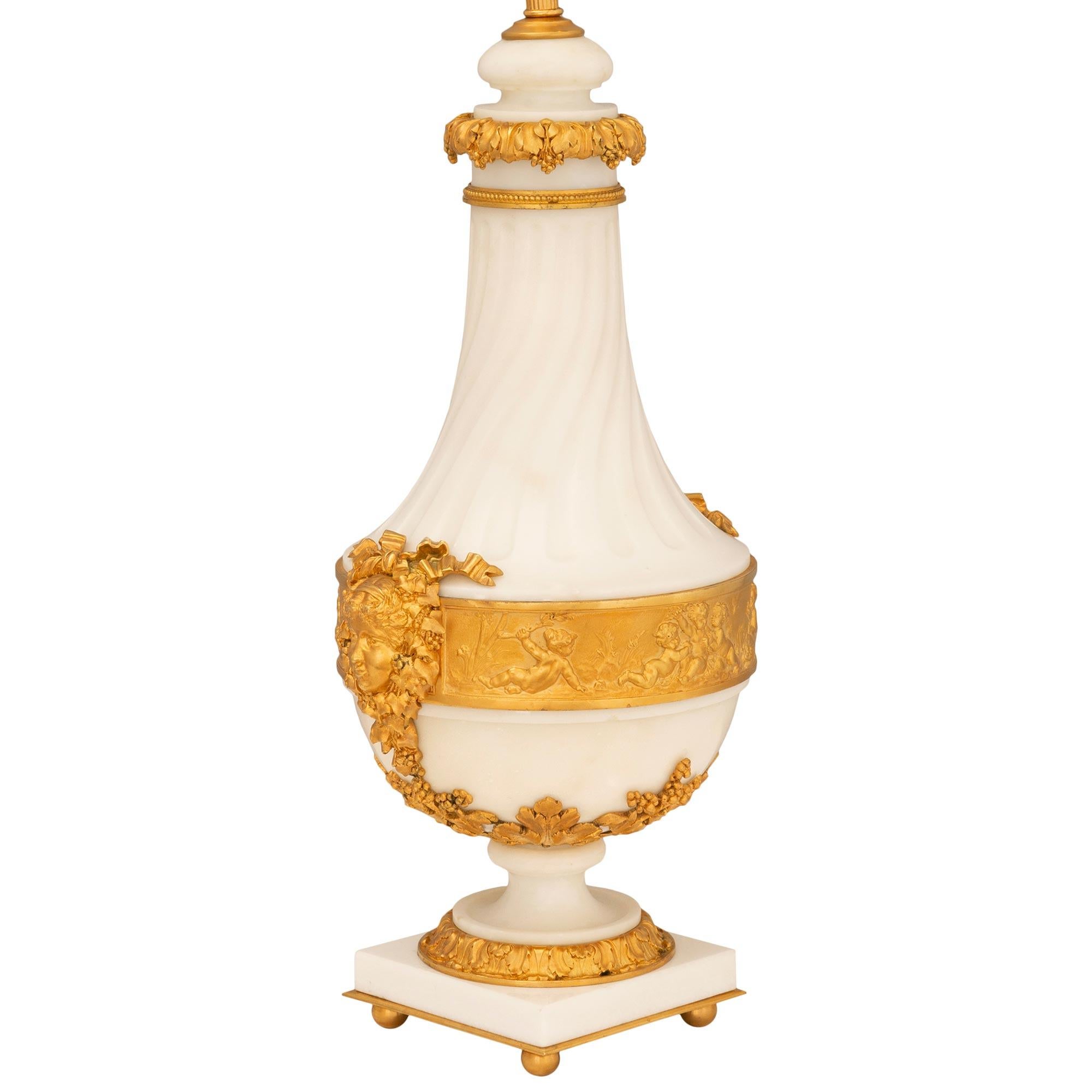 An extraordinary and very high quality pair of French 19th century Louis XVI st. white Carrara marble and ormolu lamps. Each lamp is raised by a square white Carrara marble base with elegant ball feet, a fine ormolu fillet, and a beautiful wrap