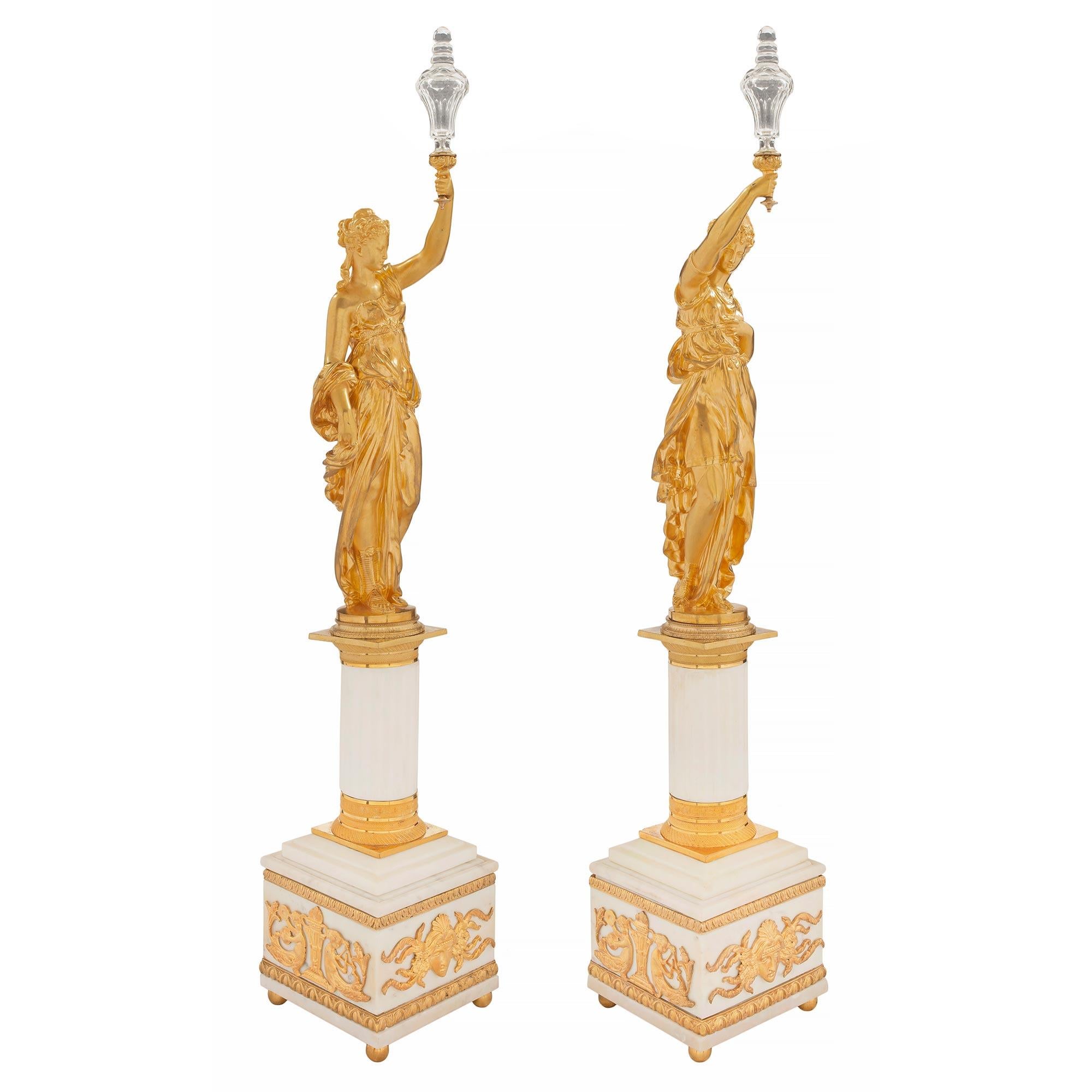 A striking and extremely high-quality true pair of French 19th century Louis XVI st. Belle Époque Period white Carrara marble, ormolu and Baccarat crystal statues. Each statue is raised by ormolu ball feet below the square white Carrara marble