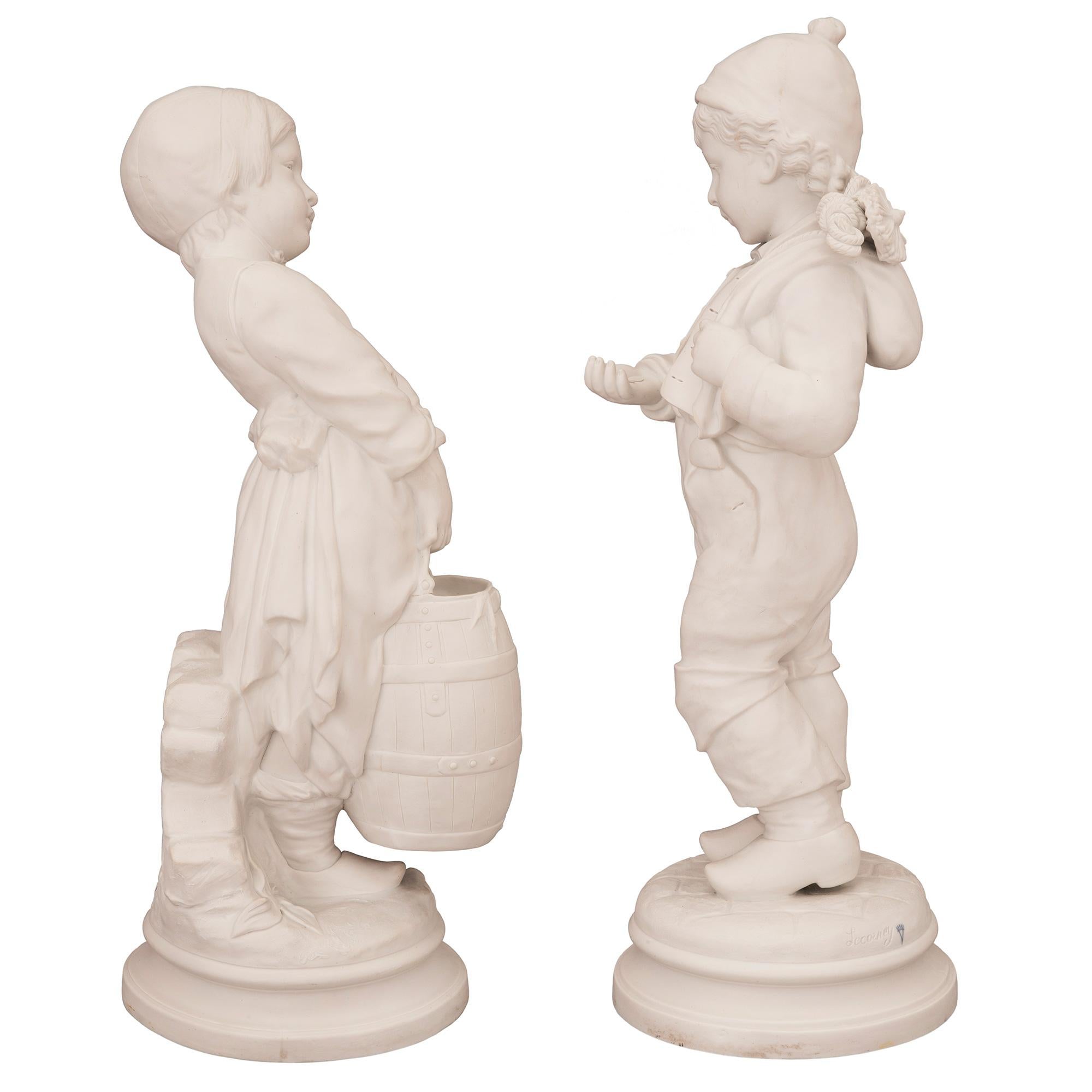 An incredibly charming pair of French 19th century Louis XVI st. Biscuit de Sèvres porcelain statues of a boy and a girl. Each statue is raised by an elegant circular mottled base with a fine ground design. To the left is a beautiful young girl