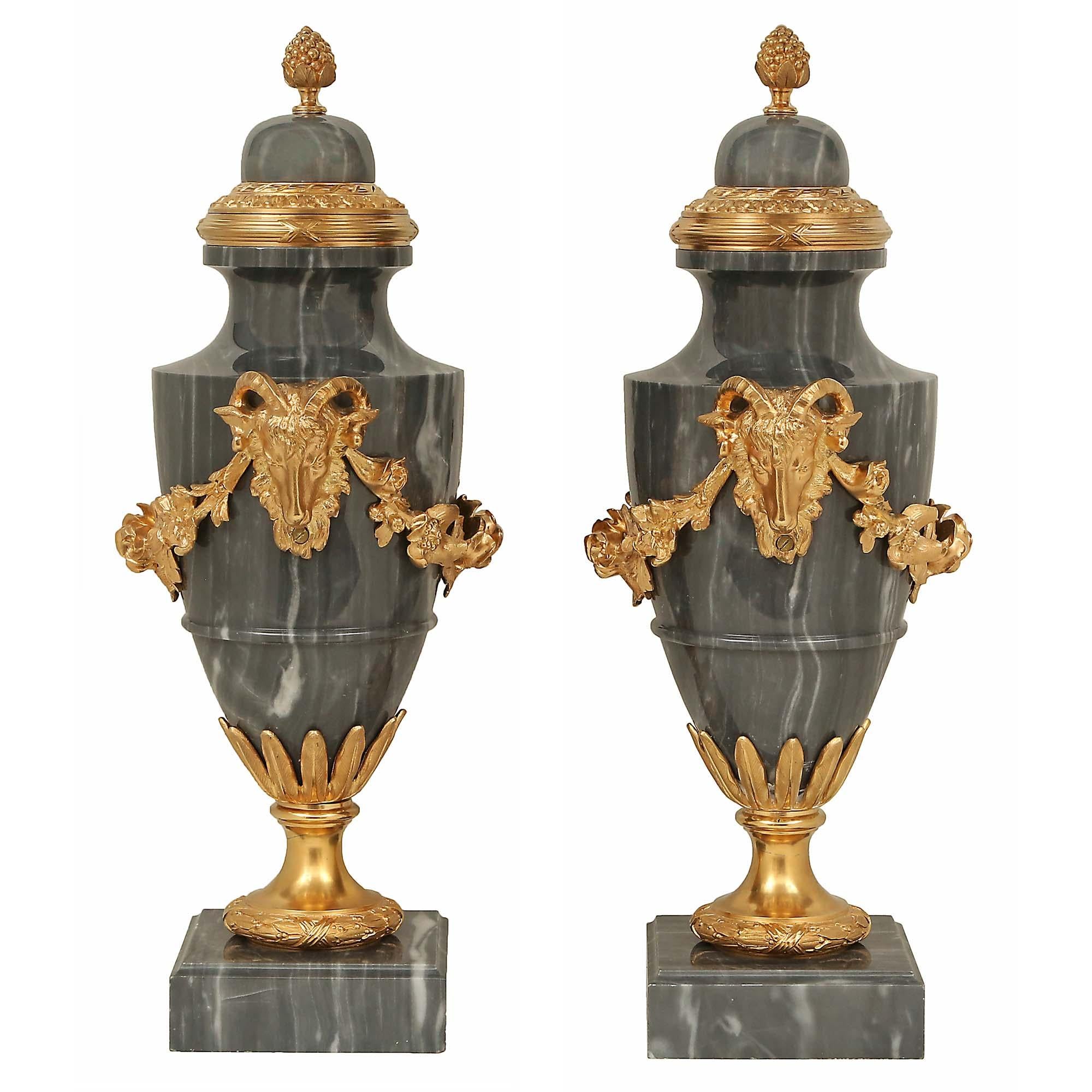 A striking pair of French 19th century Louis XVI st. Blue Turquin marble and ormolu urns. Each urn is raised by a square marble base with a mottled border and an ormolu satin and burnished socle pedestal with a finely chased berried laurel band. The