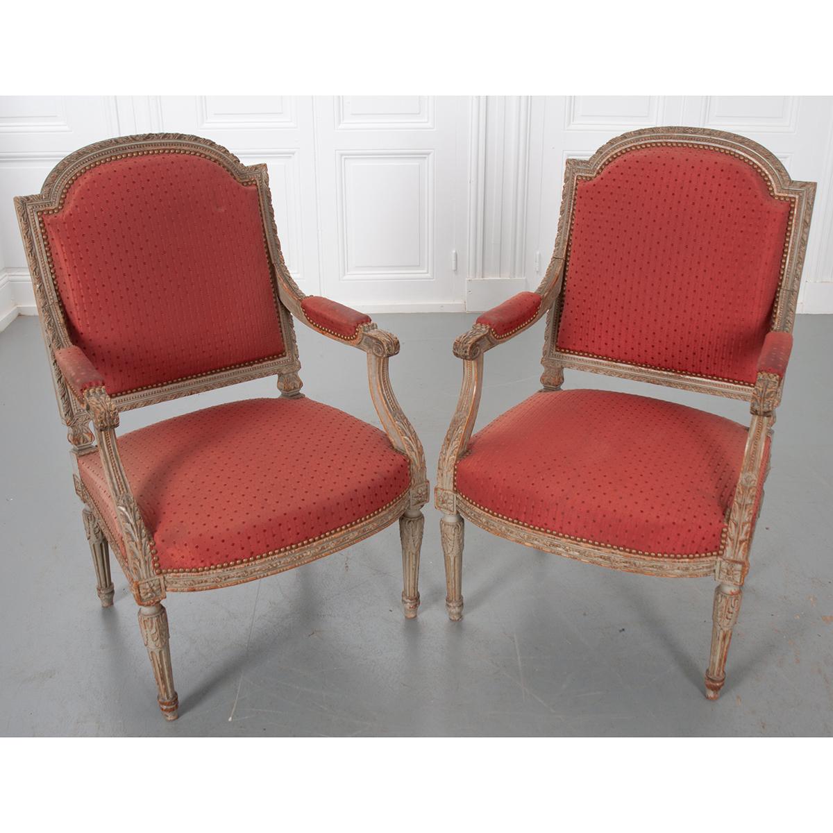 A lovely pair of painted fauteuils, upholstered in vintage red/burgundy fabric. The armchairs are beautifully carved and painted, with both the paint and hardwood acquiring an exceptional patina over time. The frame is heavily carved and sports an